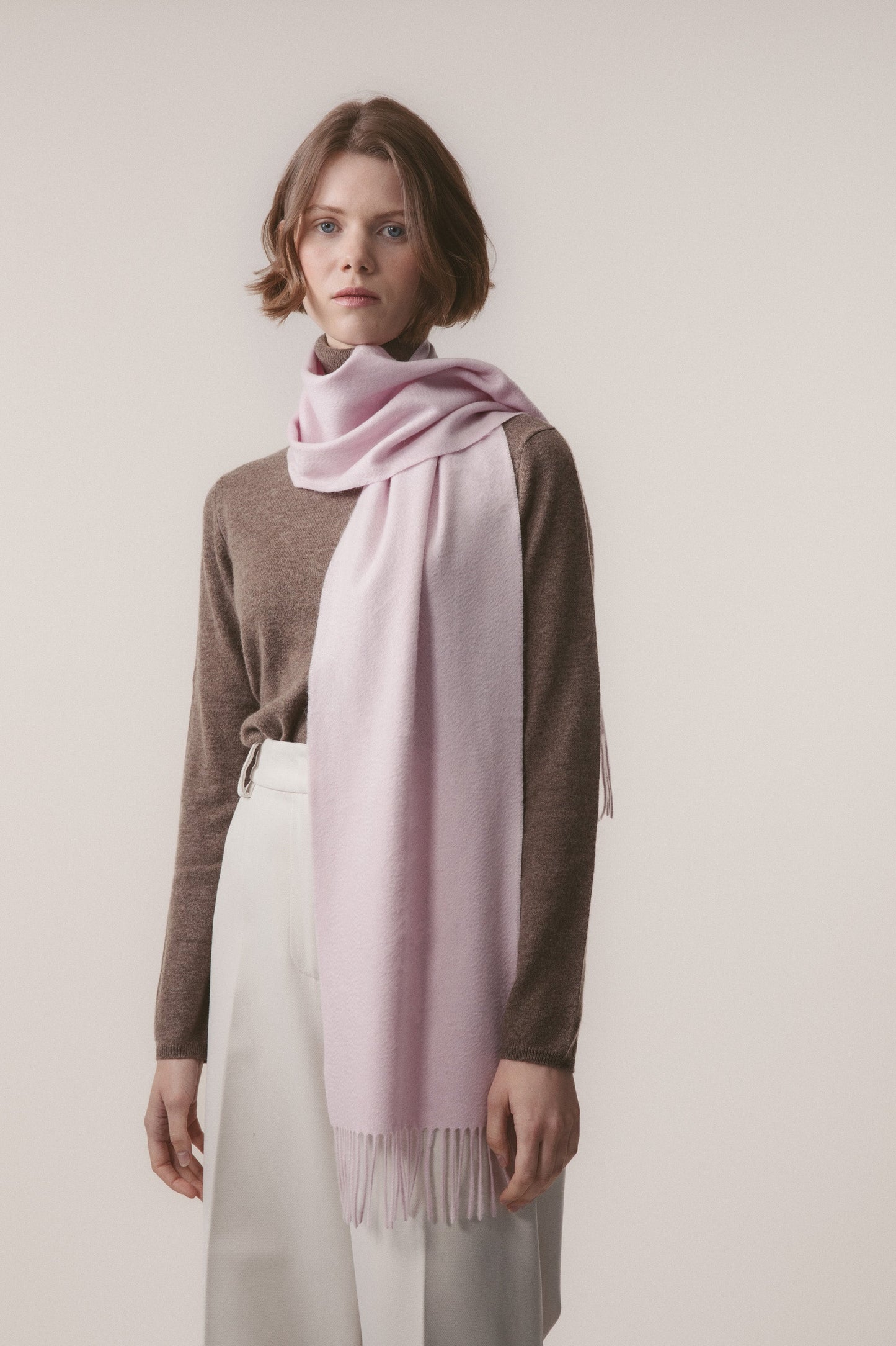 Solid Cashmere Scarf in Pale Lilac worn looped around the neck with fringed ends draping to the waist, styled with a brown sweater