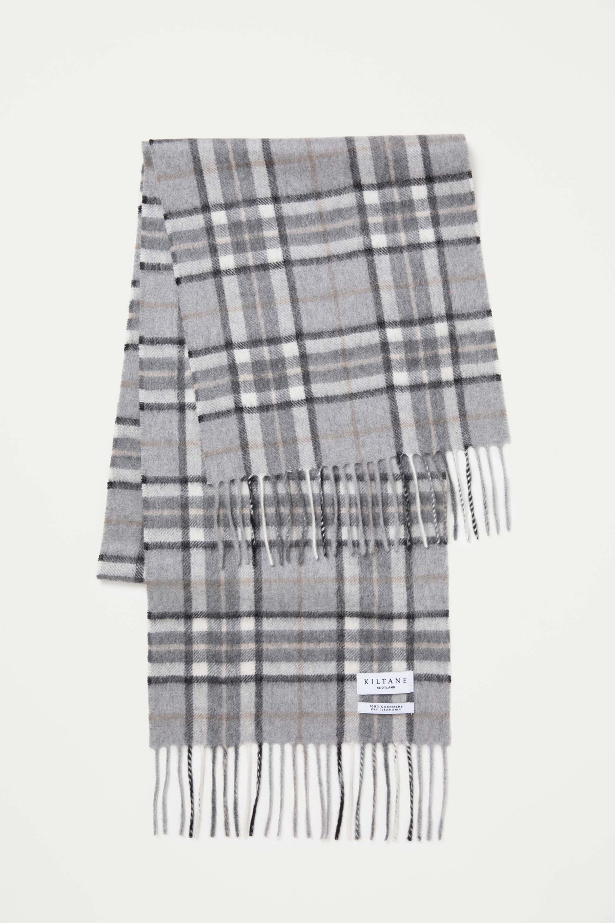 Scotty Thompson Cashmere Scarf in Pewter laid flat showing full plaid pattern with grey, black, white, and tan stripes and fringed ends