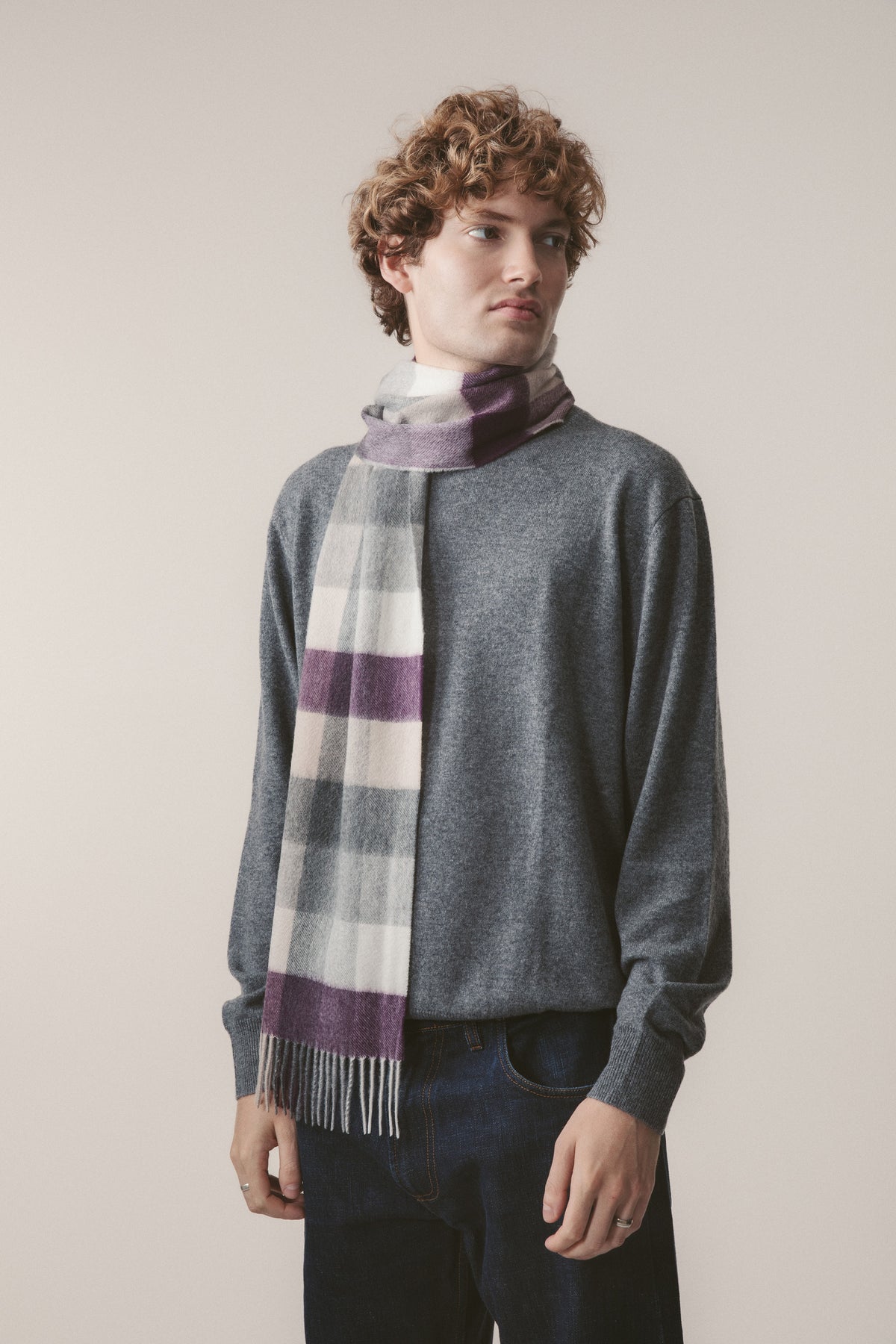 5 Square Check Cashmere Scarf in Purple Grey worn draped over a grey sweater, showing plaid pattern with fringed ends