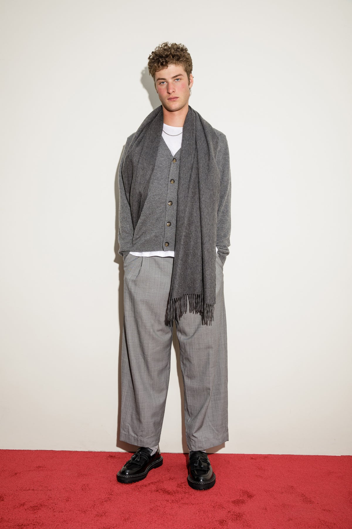 Solid Cashmere Stole in Steinway Grey draped over shoulders with fringed ends visible, styled with a grey cardigan and trousers