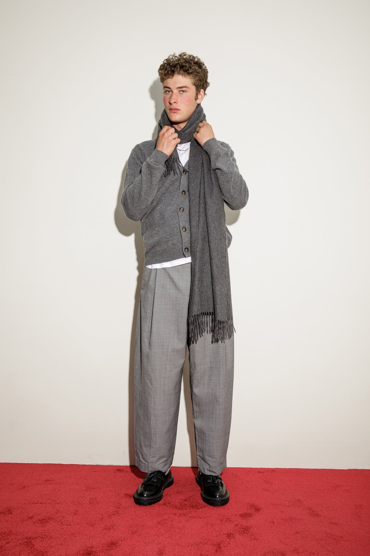 Solid Cashmere Stole in Steinway Grey worn draped around the neck with fringed ends hanging, styled with a grey cardigan