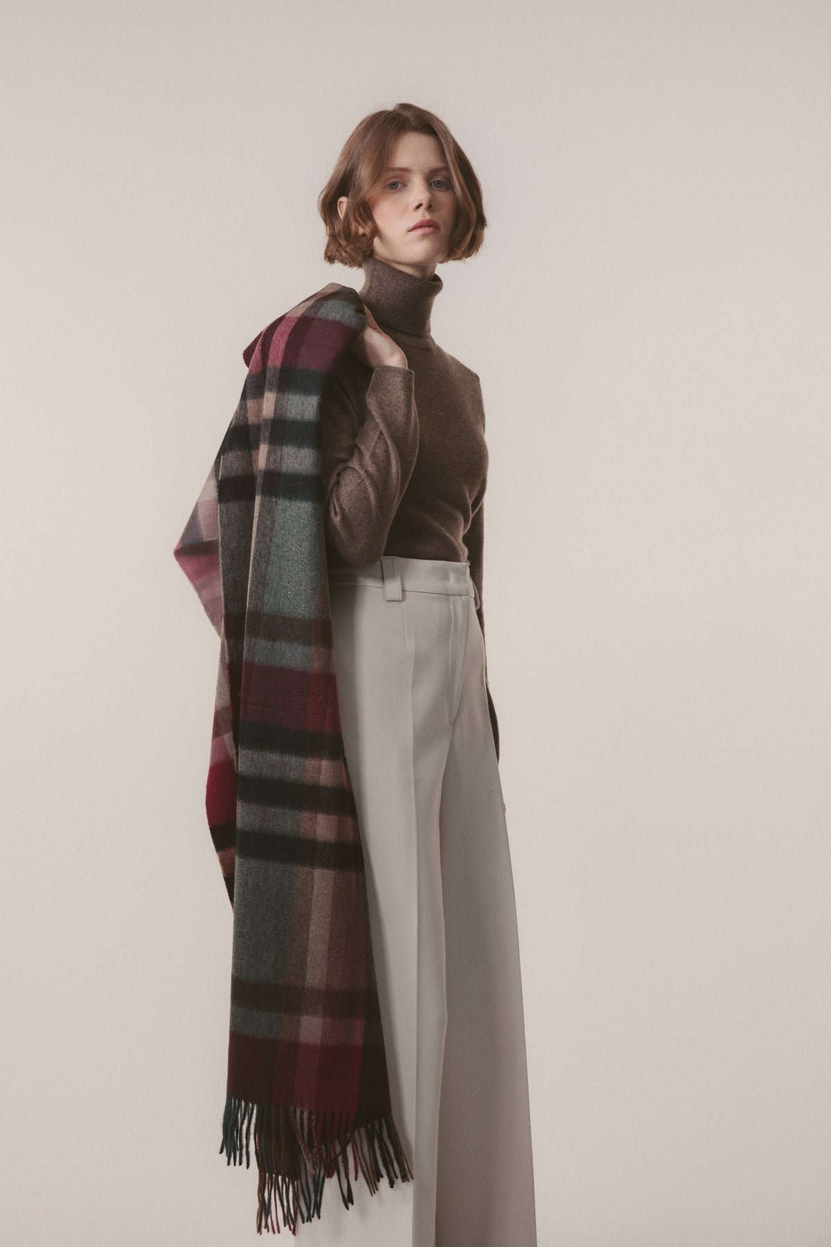 Tartan 2 Cashmere Stole in Burgundy Rust draped over one shoulder, showing full plaid pattern with fringed hem detail