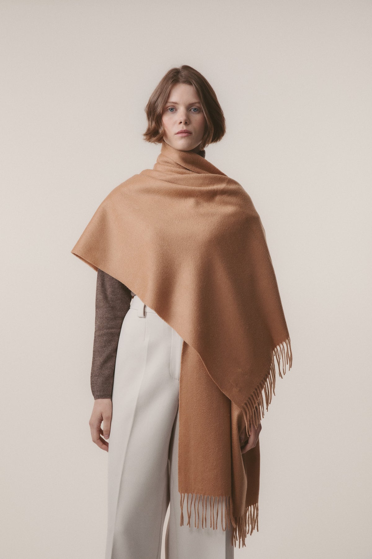 Solid Cashmere Stole in Dark Camel draped over one shoulder showing soft texture and fringed hem detail
