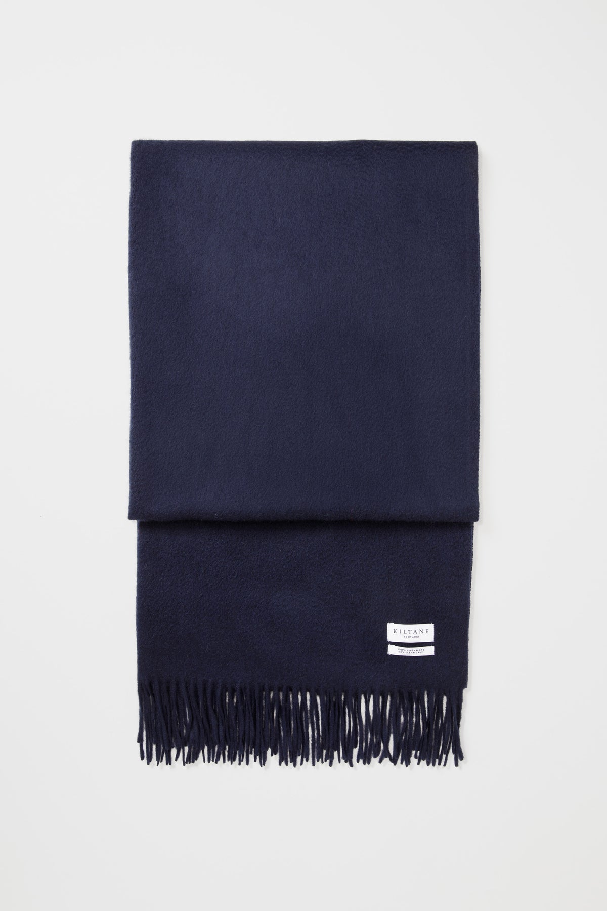Kiltane Solid Cashmere Stole in Dark Navy folded flat showing soft texture, brand label, and fringed edge detail