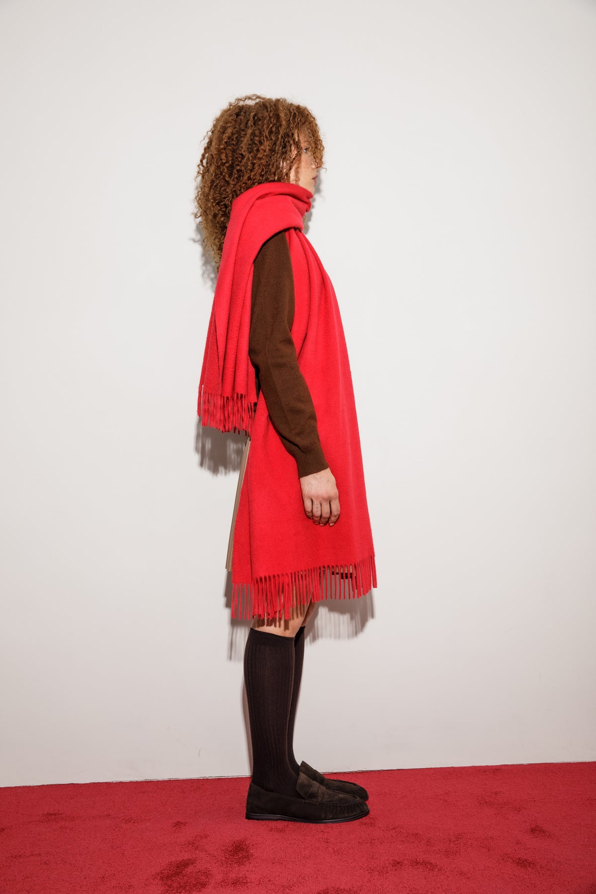 Solid Cashmere Wide Scarf in red shown in side profile, draped over shoulders with fringed ends falling to knee length