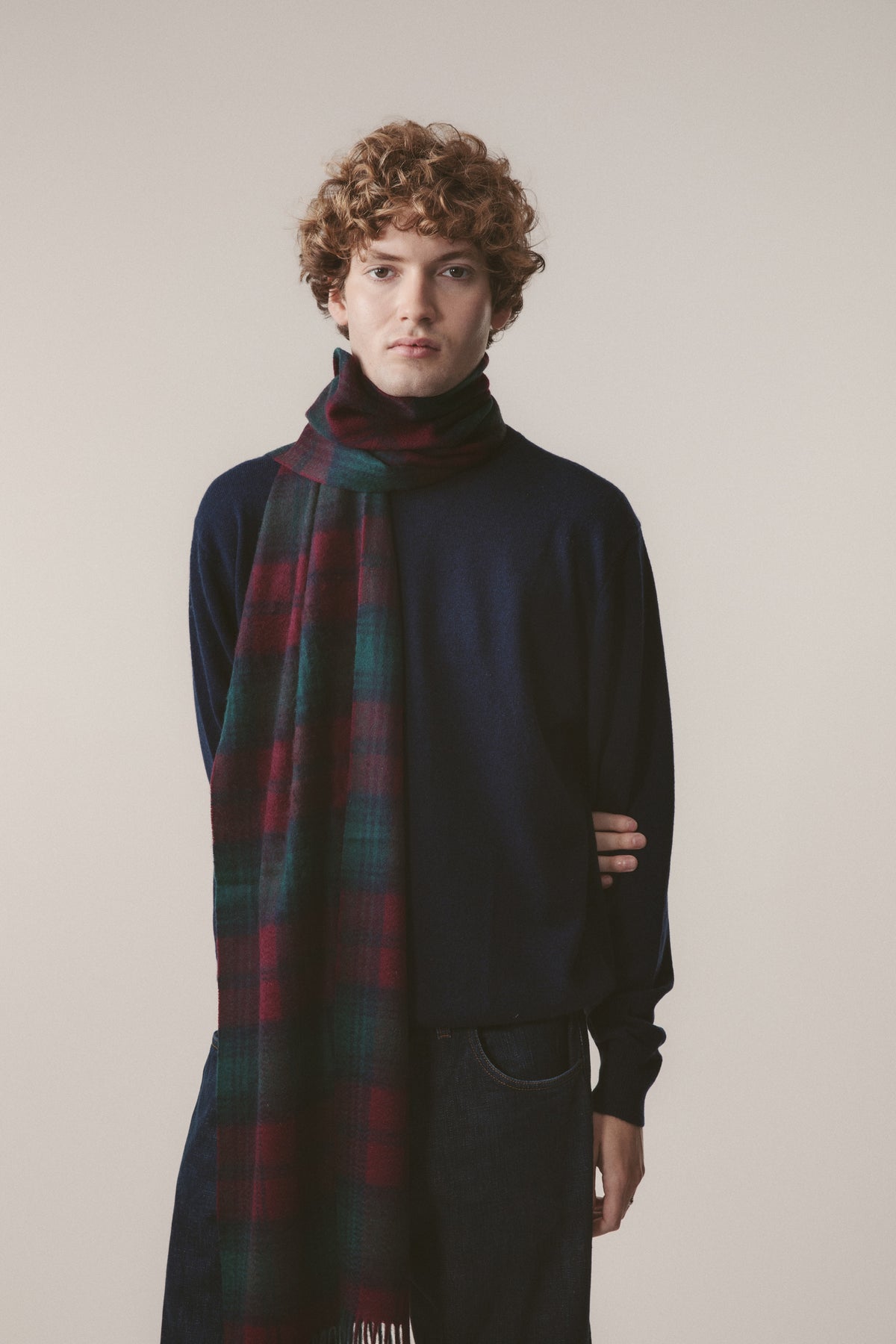 Heritage Tartan Cashmere Wide Scarf in Lindsay tartan with navy, teal, and burgundy plaid pattern and fringed ends, worn over a dark turtleneck