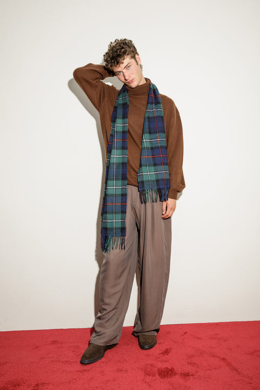 Heritage Tartan Cashmere Wide Scarf in Mackenzie tartan styled over a brown turtleneck, showing full drape length and fringed ends