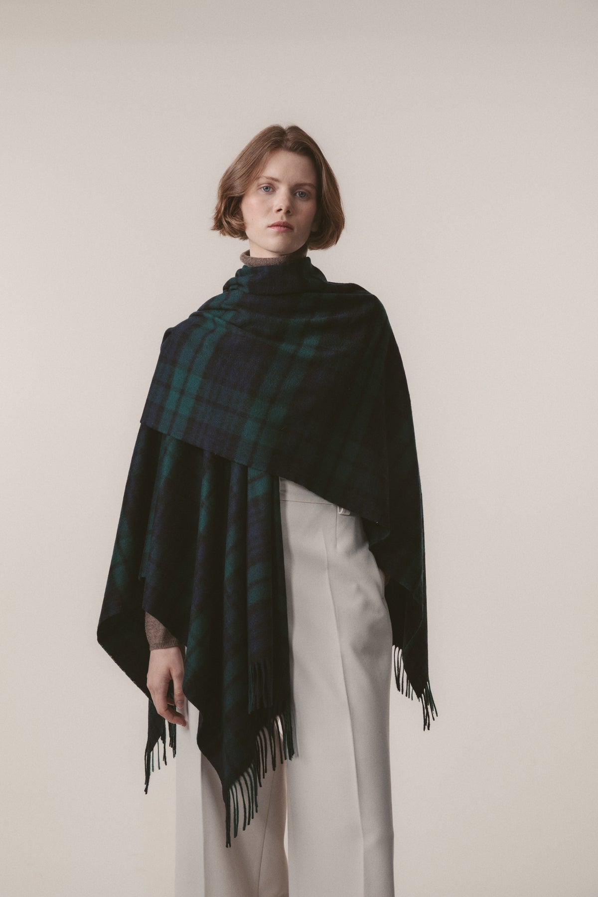 Heritage Tartan Cashmere Wrap in Blackwatch draped over shoulders showing full front drape and fringed hem detail