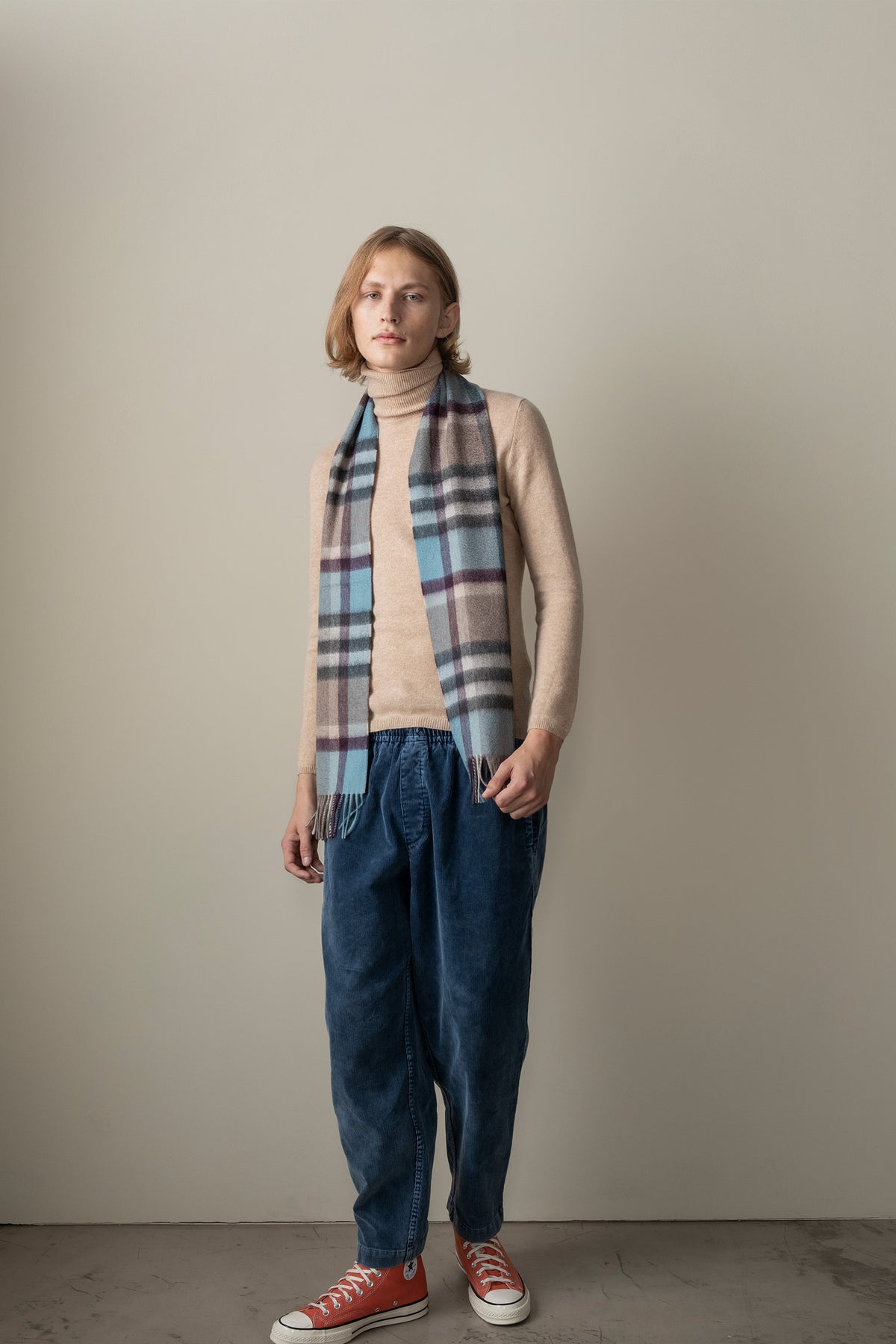 Tartan 2 Cashmere Scarf in Blue Taupe worn draped over shoulders, featuring light blue and taupe plaid pattern with fringe ends