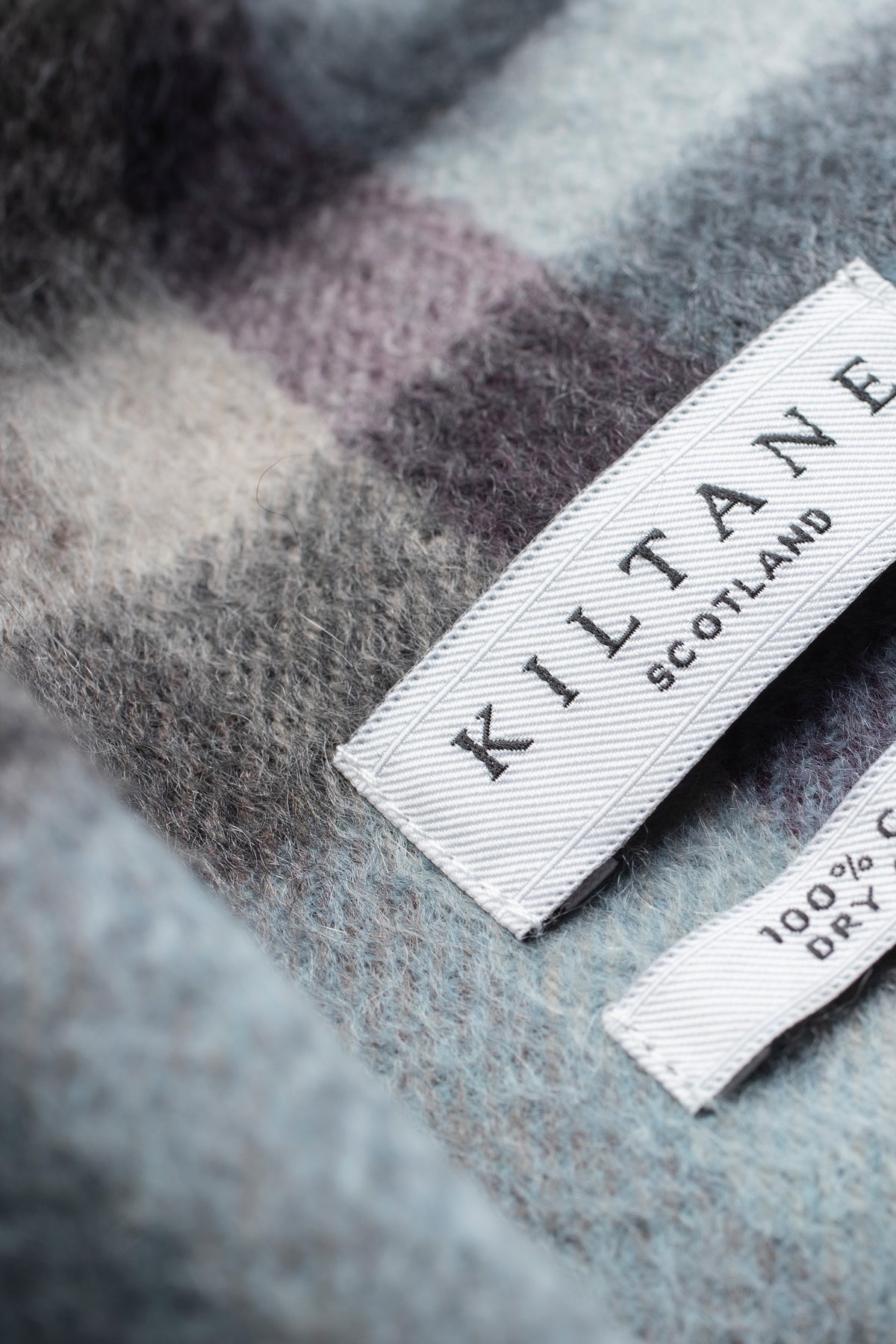 Close-up of Kiltane Scotland label on Tartan 2 Cashmere Scarf in Blue Taupe showing soft brushed cashmere texture