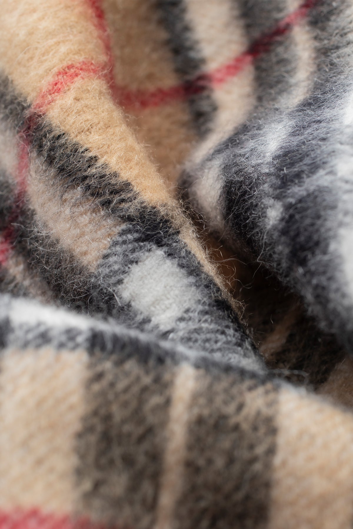 Close-up of Scotty Thompson Cashmere Scarf in Camel showing soft brushed texture and classic plaid pattern in camel, grey, and red