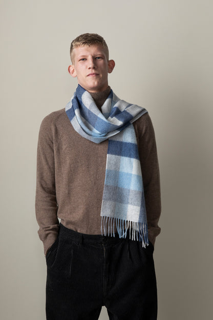 5 Square Check Cashmere Scarf in Glacier blue plaid pattern with fringed ends, worn looped around the neck over a brown sweater