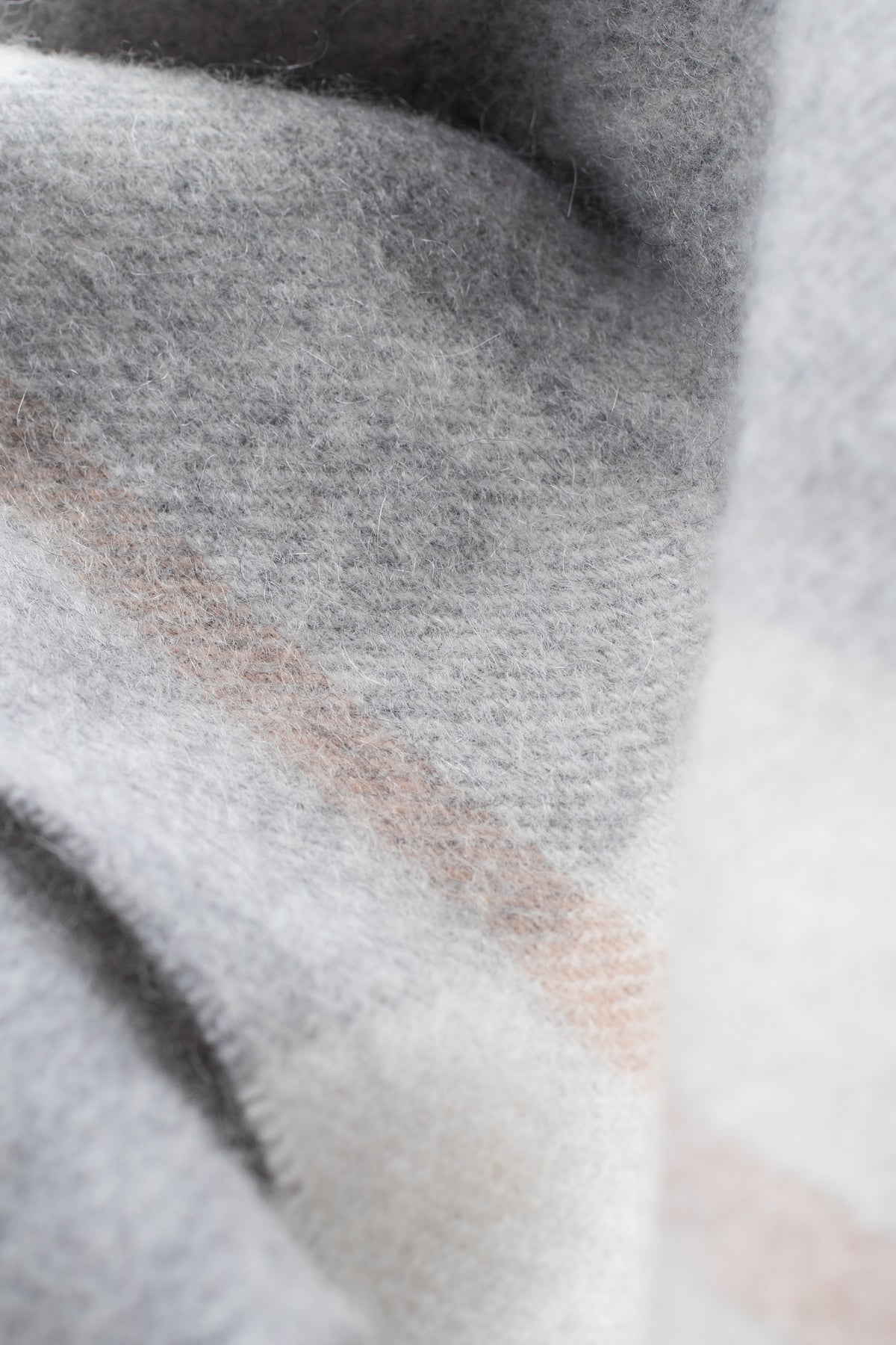 Close-up of the Contemporary Check Cashmere Scarf in Grey showing soft brushed texture with subtle blush pink check detail