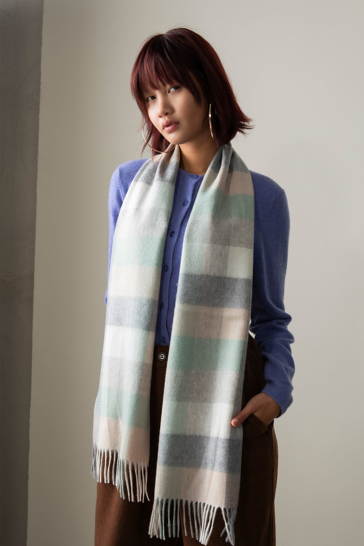 5 Square Check Cashmere Scarf in Brume worn draped over shoulders, featuring soft mint, grey, and cream plaid with fringed ends