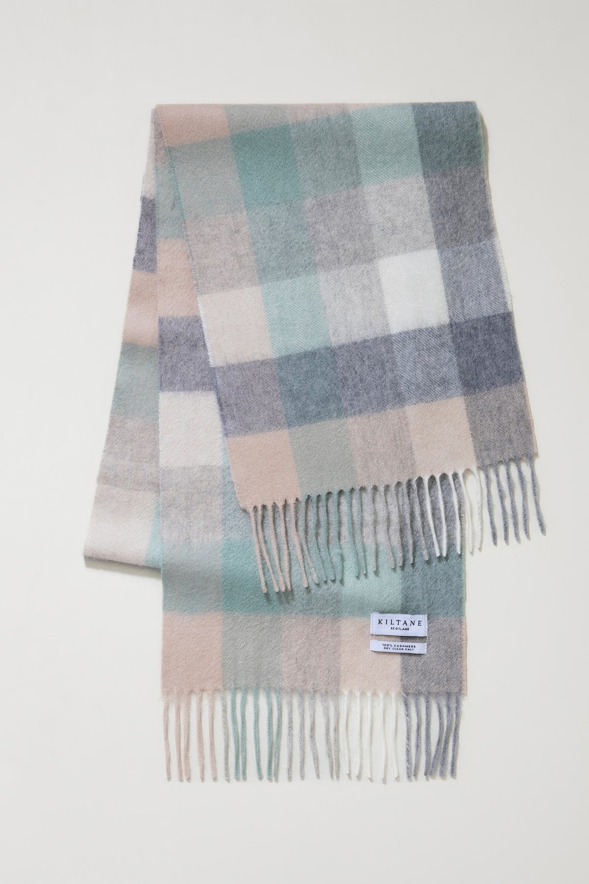 5 Square Check Cashmere Scarf in Brume folded flat showing full check pattern in soft green, pink, grey, and cream with fringed ends