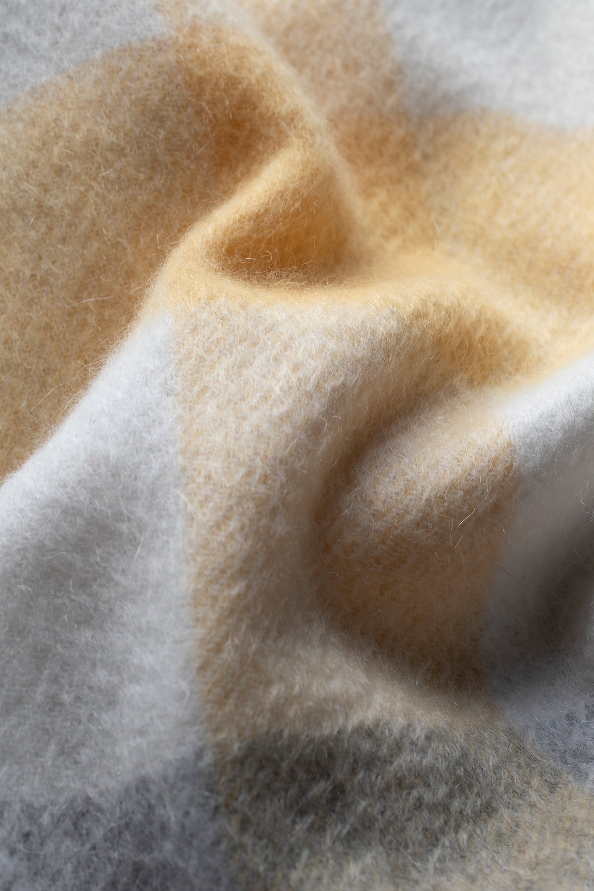 Close-up of 5 Square Check Cashmere Scarf in Butter showing soft brushed texture in warm golden and pale grey tones