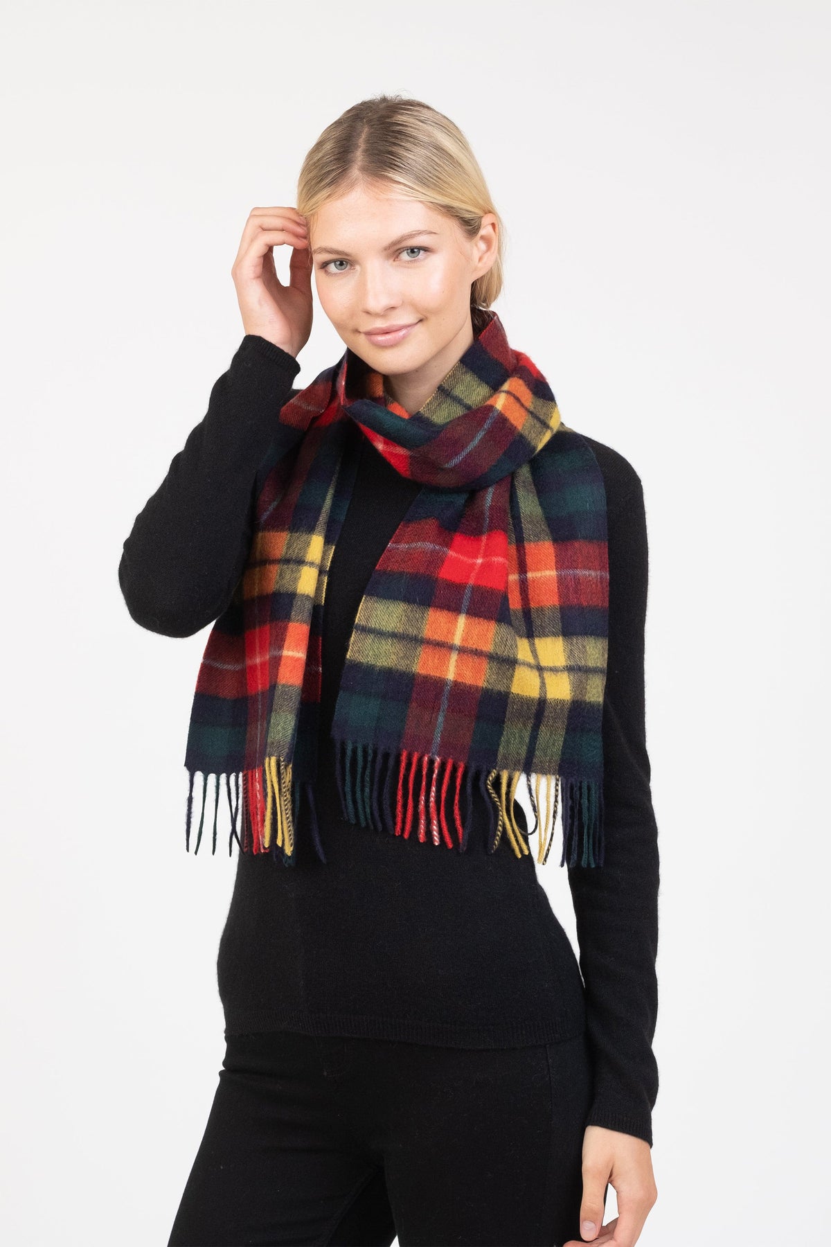 Heritage Tartan Cashmere Scarf in Buchanan Modern pattern with red, yellow, green, and navy plaid, fringed ends, worn styled over a black sweater