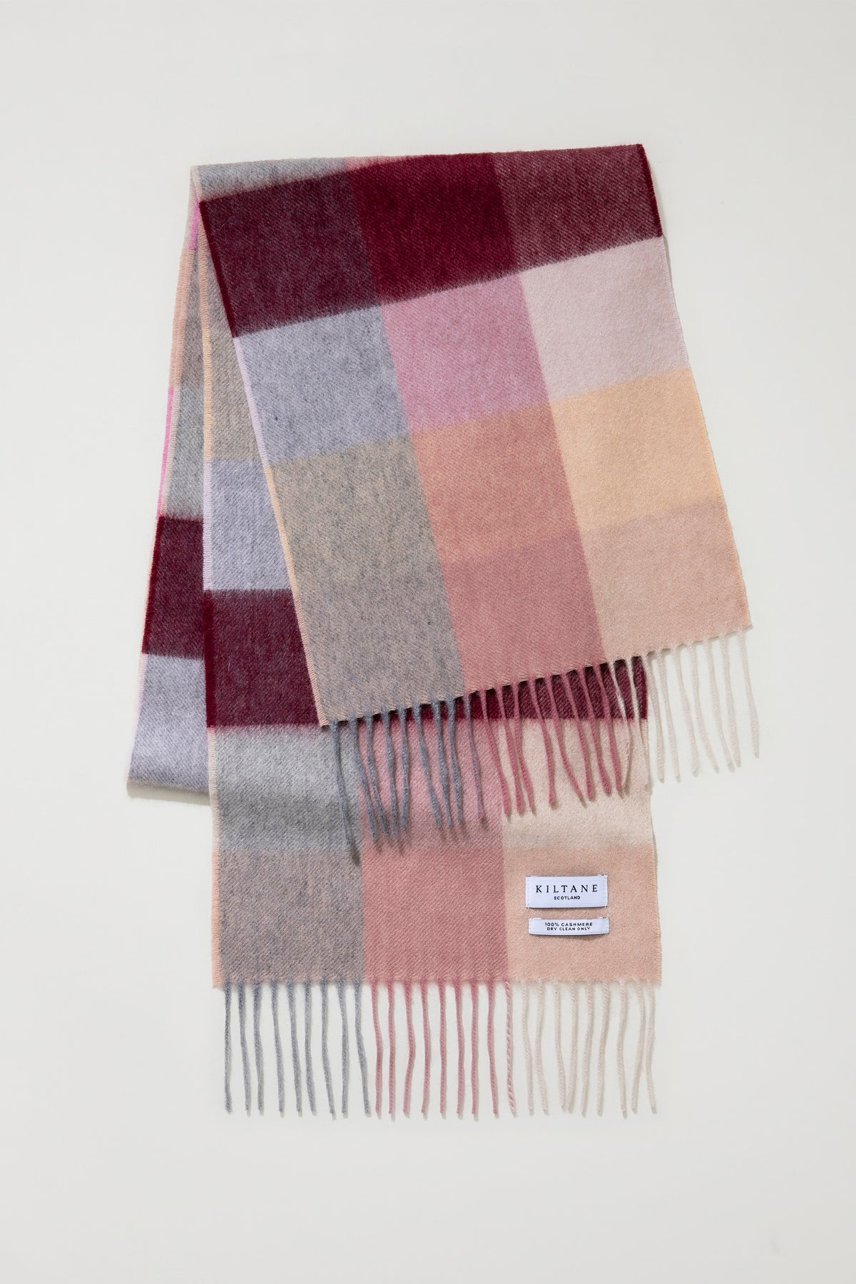 3 Square Cashmere Scarf in Summer Fruits folded to show colour-block pattern in burgundy, pink, peach, and grey with fringed ends