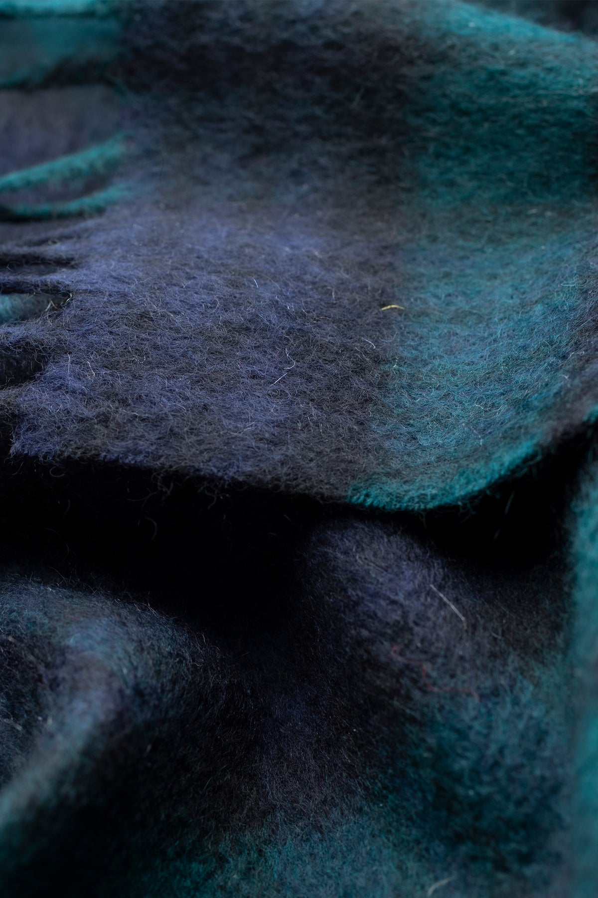 Close-up of Heritage Tartan Cashmere Scarf in Blackwatch showing soft brushed texture and deep navy-green plaid pattern