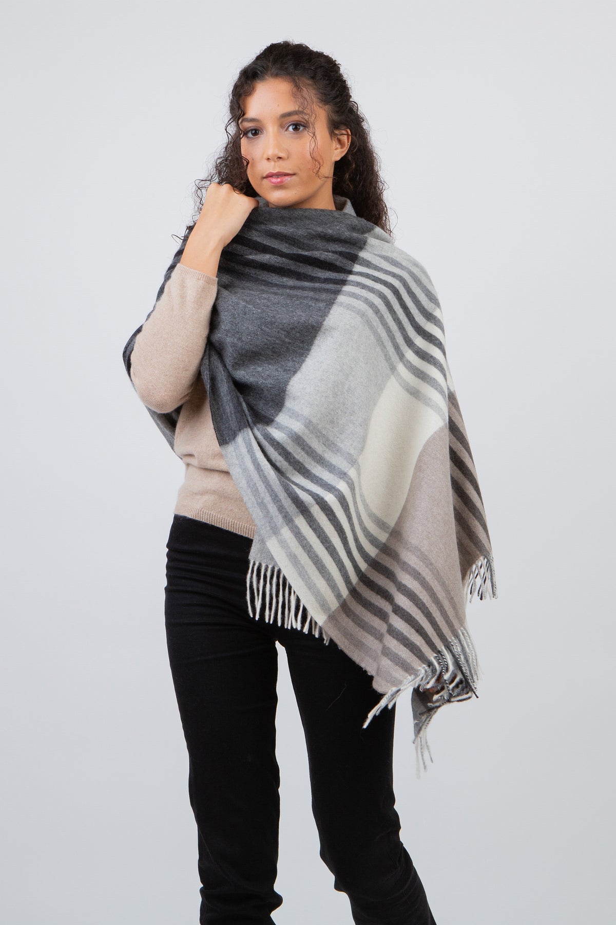Contemporary Check Cashmere Stole in Monochrome worn draped over shoulders, featuring grey, black, and cream plaid with fringe hem