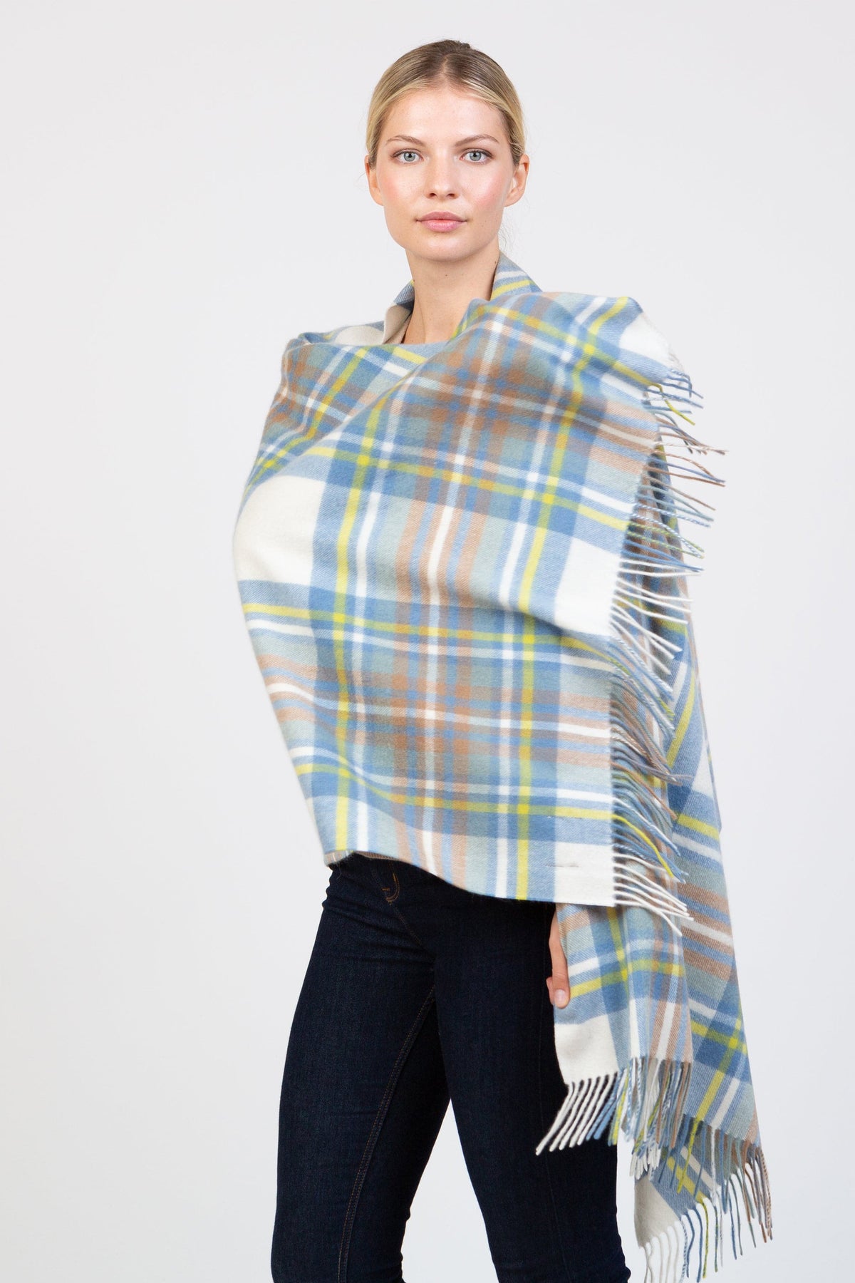 Model wearing Heritage Tartan Cashmere Stole in Muted Blue Stewart draped over shoulders, showing full tartan pattern and fringed edges