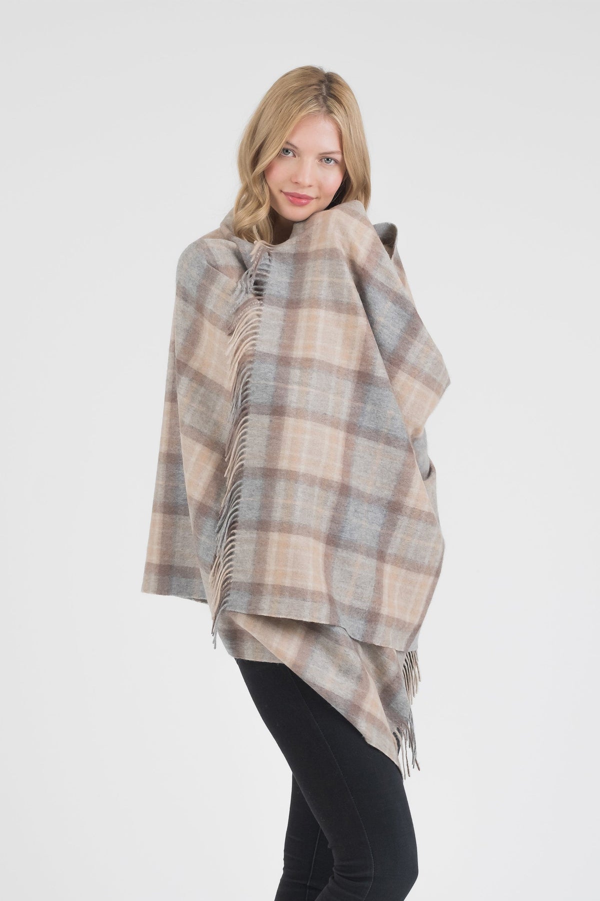 Model wrapping the Heritage Tartan Cashmere Stole in Mackellar Natural around her shoulders, showing the soft plaid drape and fringed edges