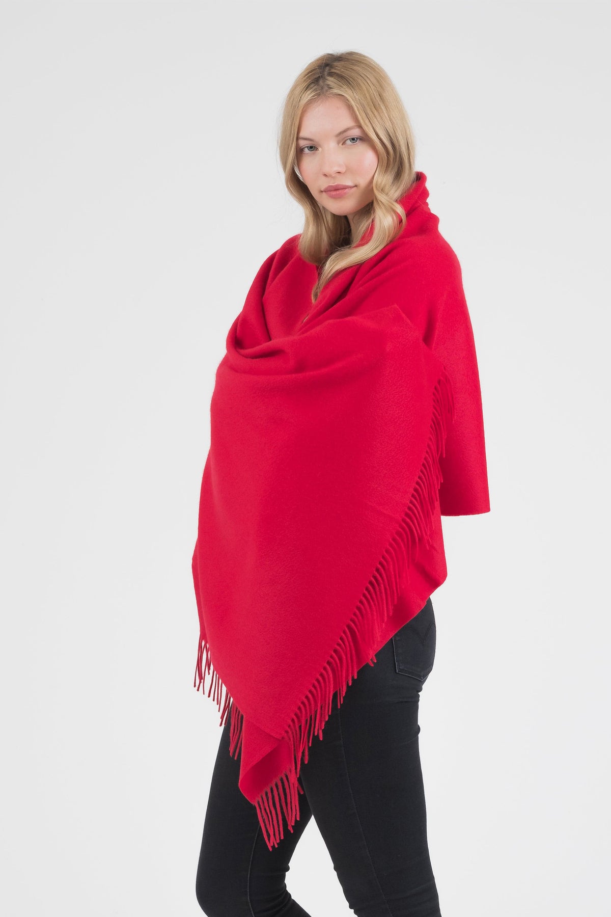 Model wearing the Solid Cashmere Stole in Red draped over shoulders, showing fringed edge detail and soft drape