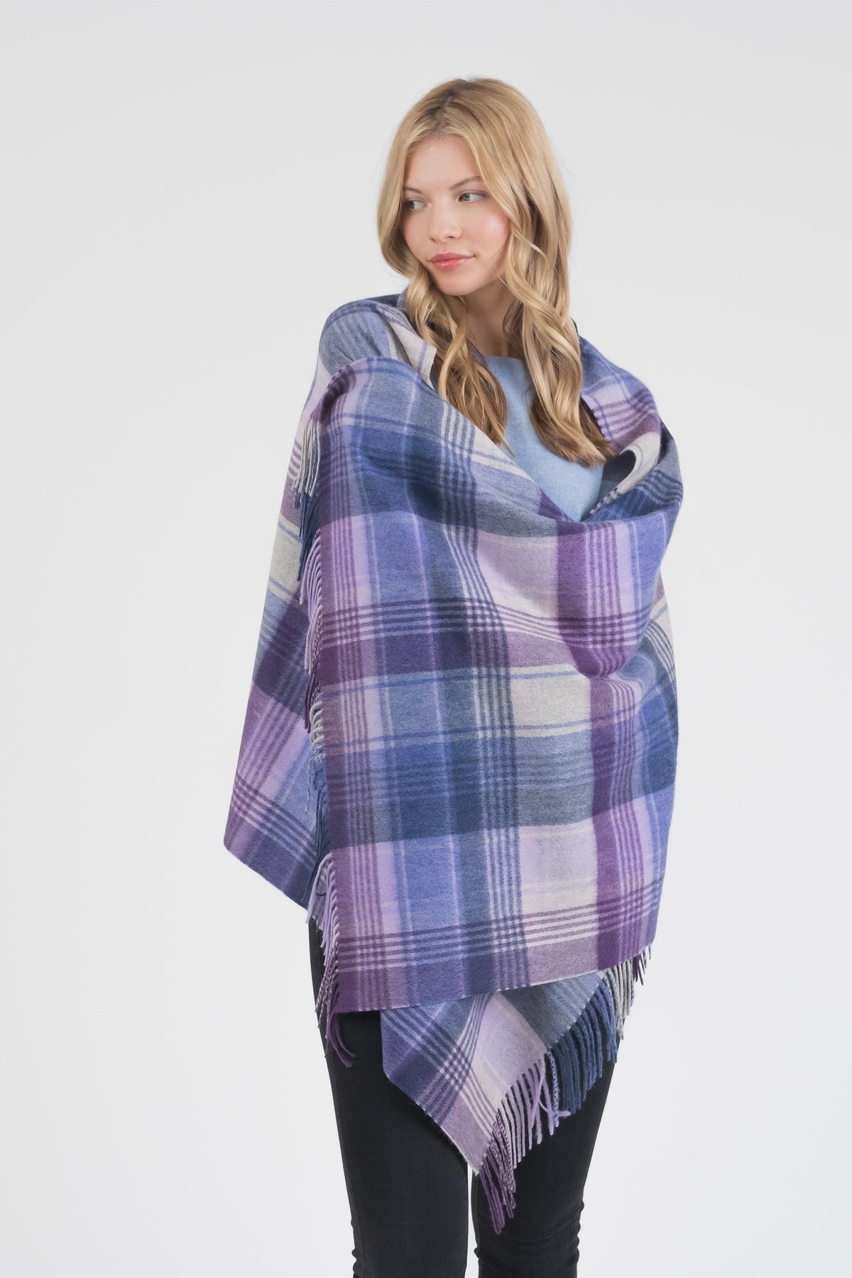 Model wearing Repeat Edge Cashmere Stole in Purple, draped over shoulders showing full plaid pattern with fringed edges