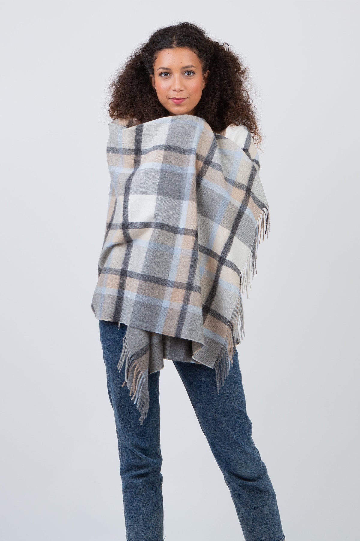 Princeton Check Cashmere Stole in Blue worn wrapped around shoulders, featuring soft plaid pattern in blue, grey, and beige with fringed edges