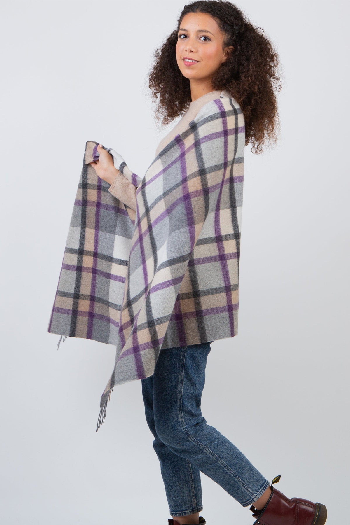 Model wearing the Princeton Check Cashmere Stole in Lavender draped as a wrap, showing the grey, purple, and beige plaid pattern with fringed edge