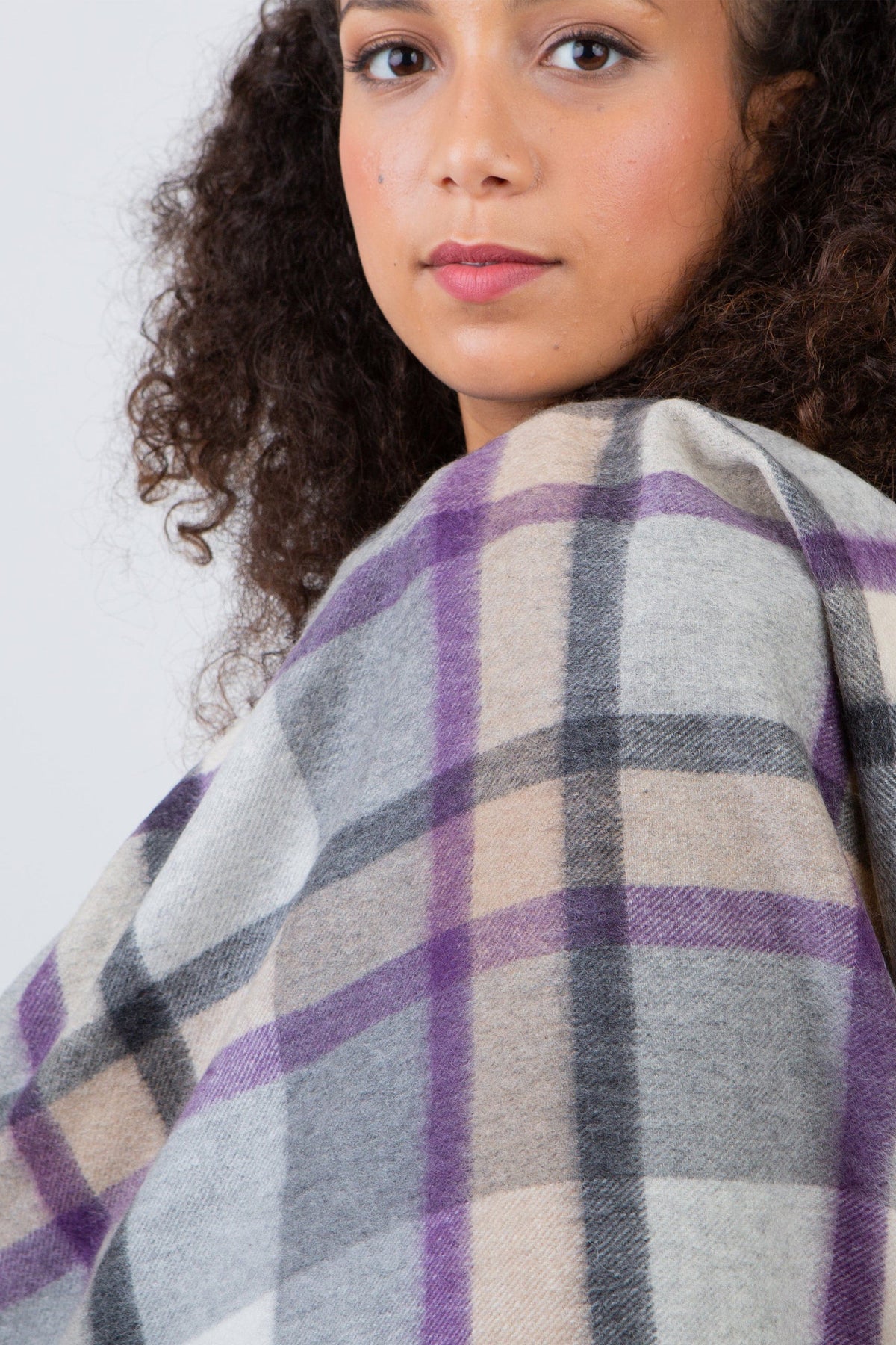 Model wearing Princeton Check Cashmere Stole in Lavender draped over shoulders, showing soft plaid pattern in purple, grey, and beige