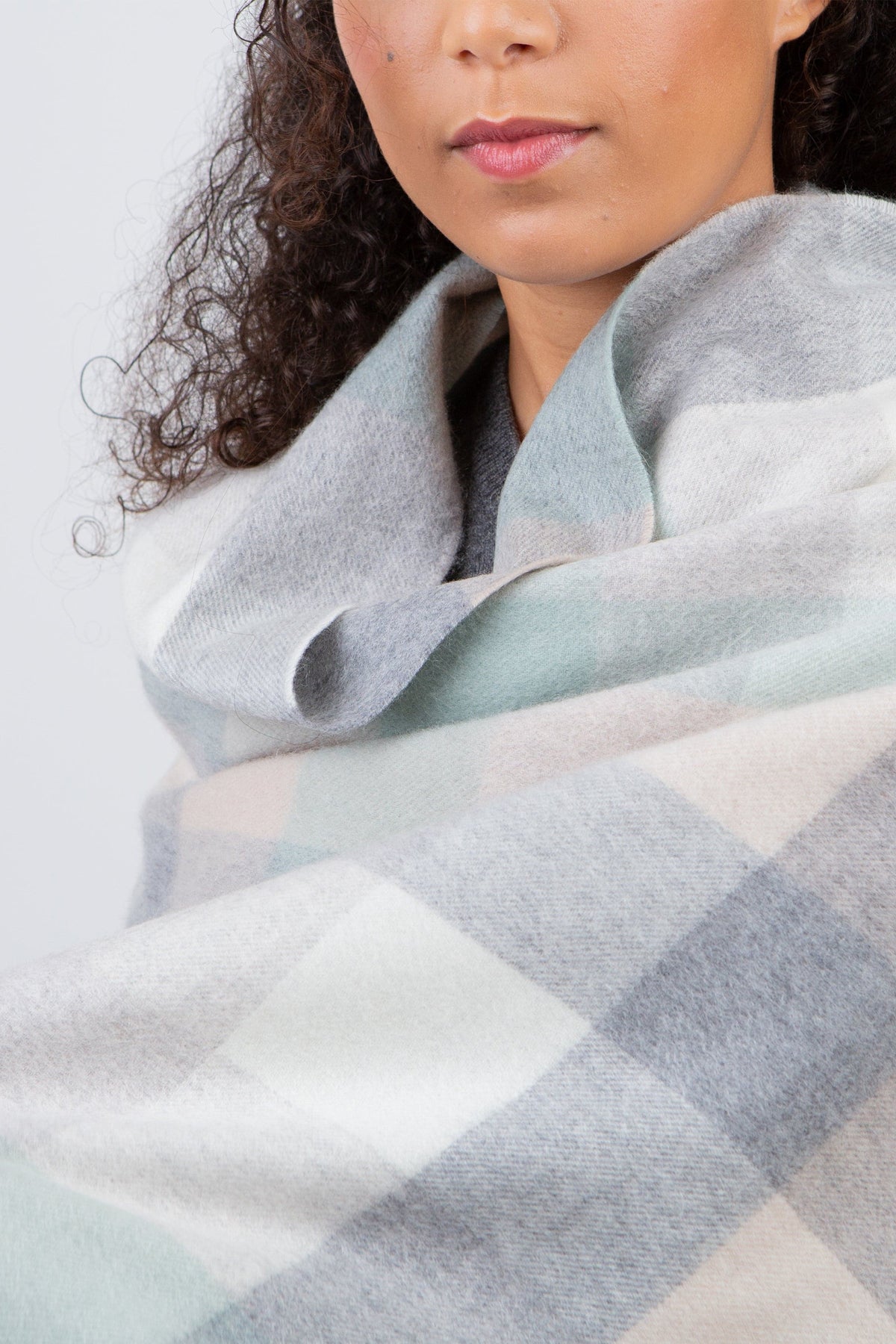 5 Square Check Cashmere Stole in Brume wrapped snugly around shoulders, showing soft plaid pattern in mint, grey, and cream