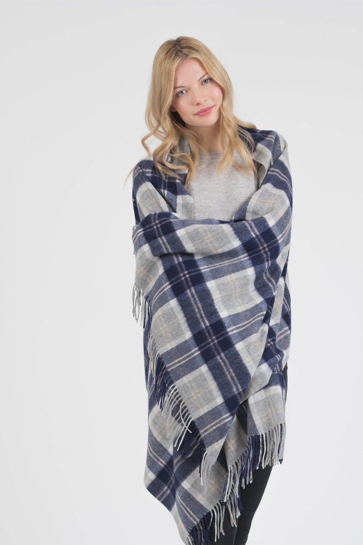 Heritage Tartan Cashmere Stole in Silver Bannockbane wrapped around shoulders, showing navy and grey plaid pattern with fringed edges