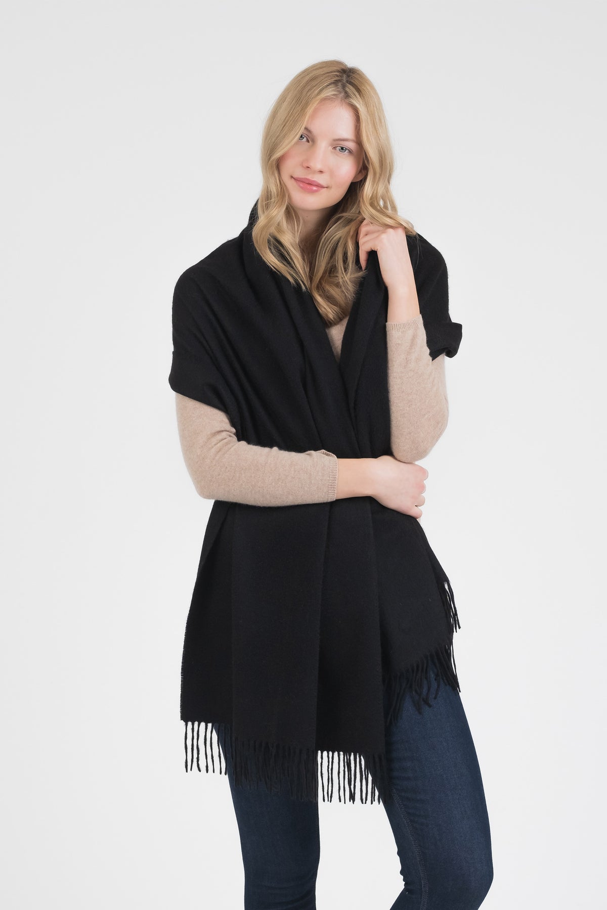 Solid Cashmere Stole in Black worn draped over shoulders with fringed ends, styled over a beige sweater