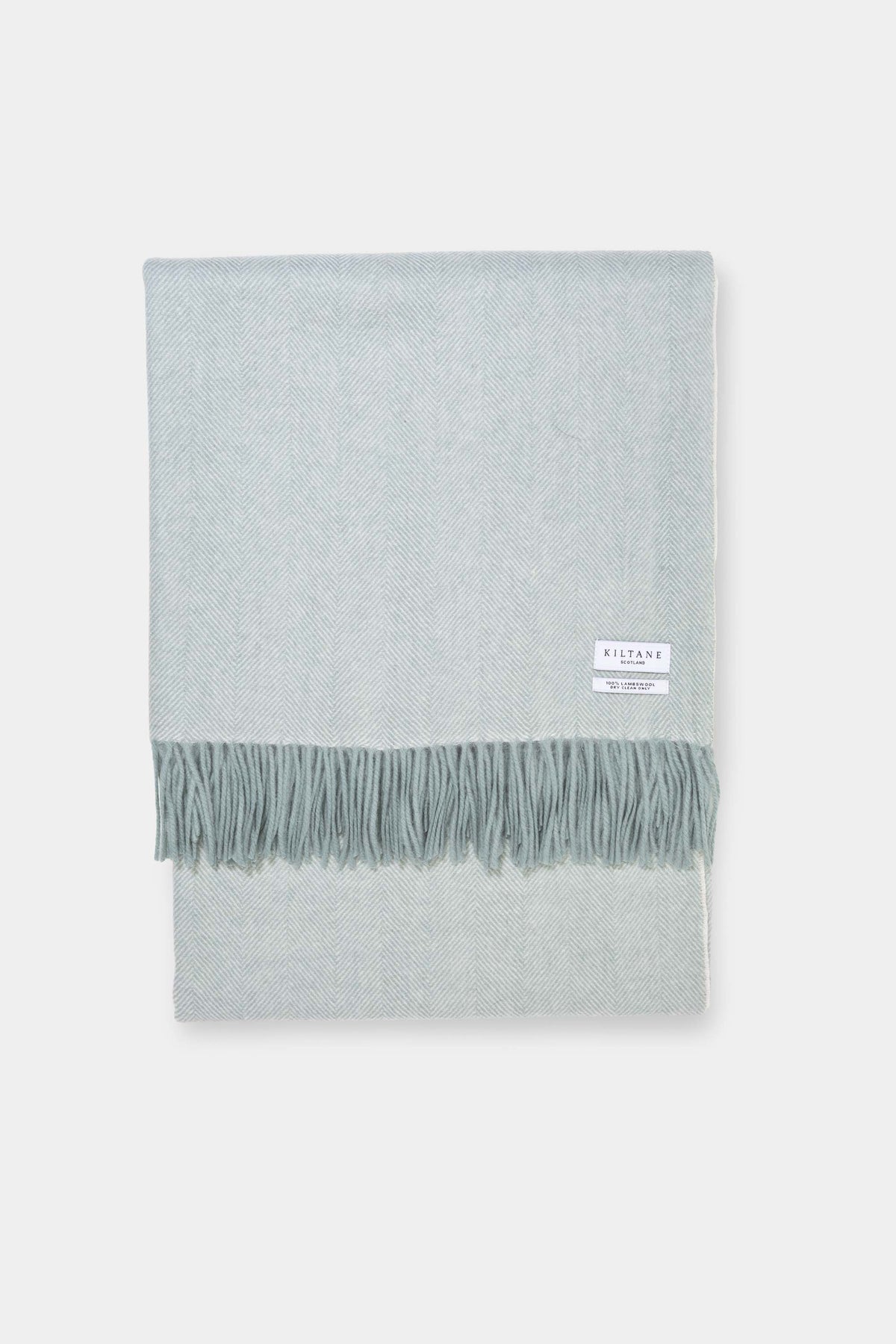 Kiltane Herringbone Lambswool Throw in Chappel Green, folded flat showing soft herringbone weave and fringed edge