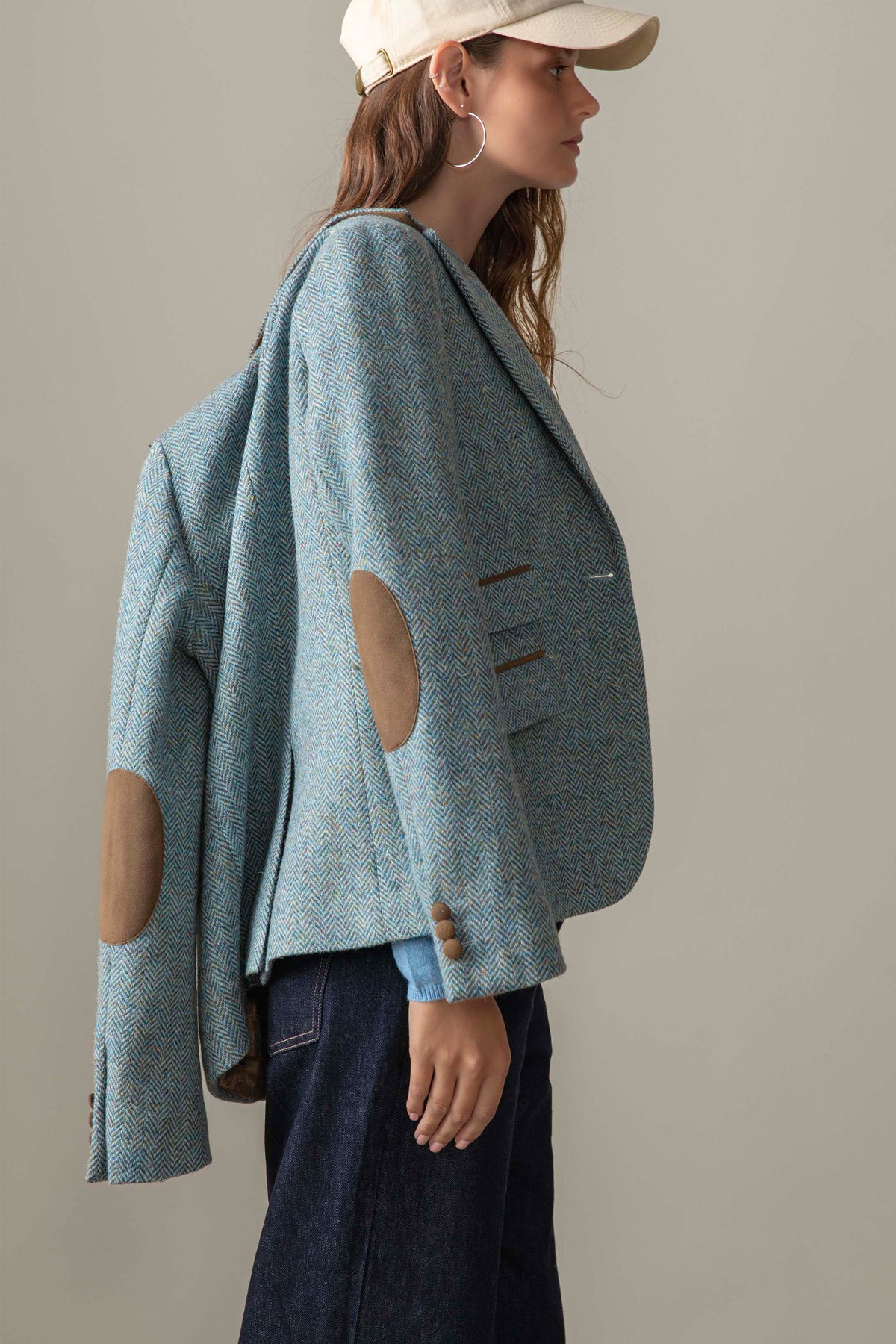 Side profile of Women's Harris Tweed Janice Blazer in light blue herringbone showing tan suede elbow patches and buttonhole detail