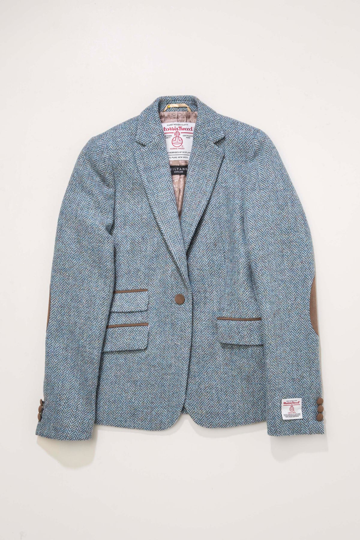 Women's Harris Tweed Janice Blazer in light blue herringbone mix, flat lay showing brown suede elbow patches and trim details