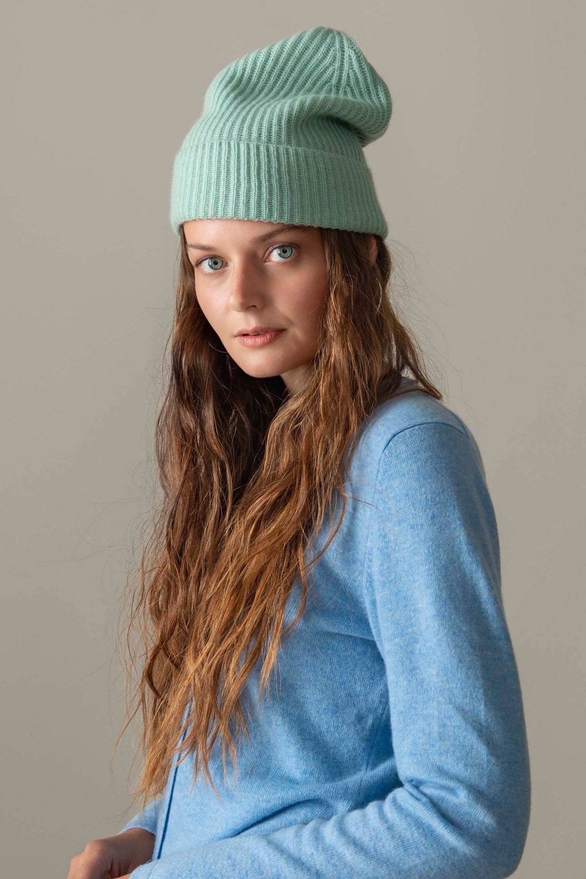 Unisex Cashmere Ribbed Beanie Hat in Brume mint green, worn by model showing soft ribbed knit texture and folded cuff