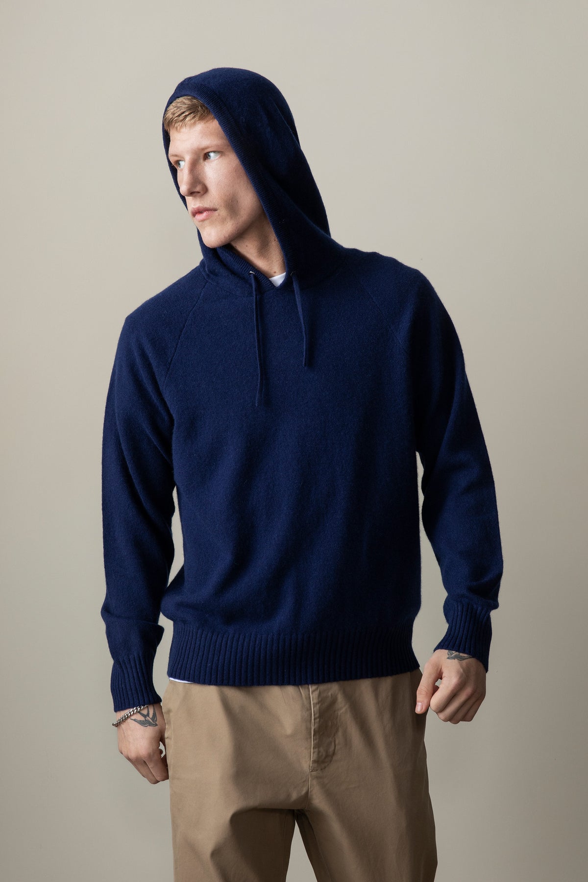 Model wearing the Unisex Cashmere Hoodie in Eclipse navy with hood up, showing relaxed fit and raglan sleeves