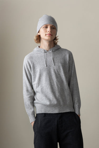 Unisex Cashmere Hoodie in light grey with drawstring hood and ribbed cuffs, modelled front-on with a relaxed fit