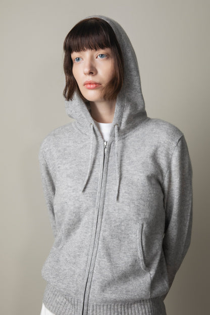 Unisex Cashmere Zip Hoodie in light grey, worn with hood up showing soft knit texture, full zip front, and kangaroo pocket