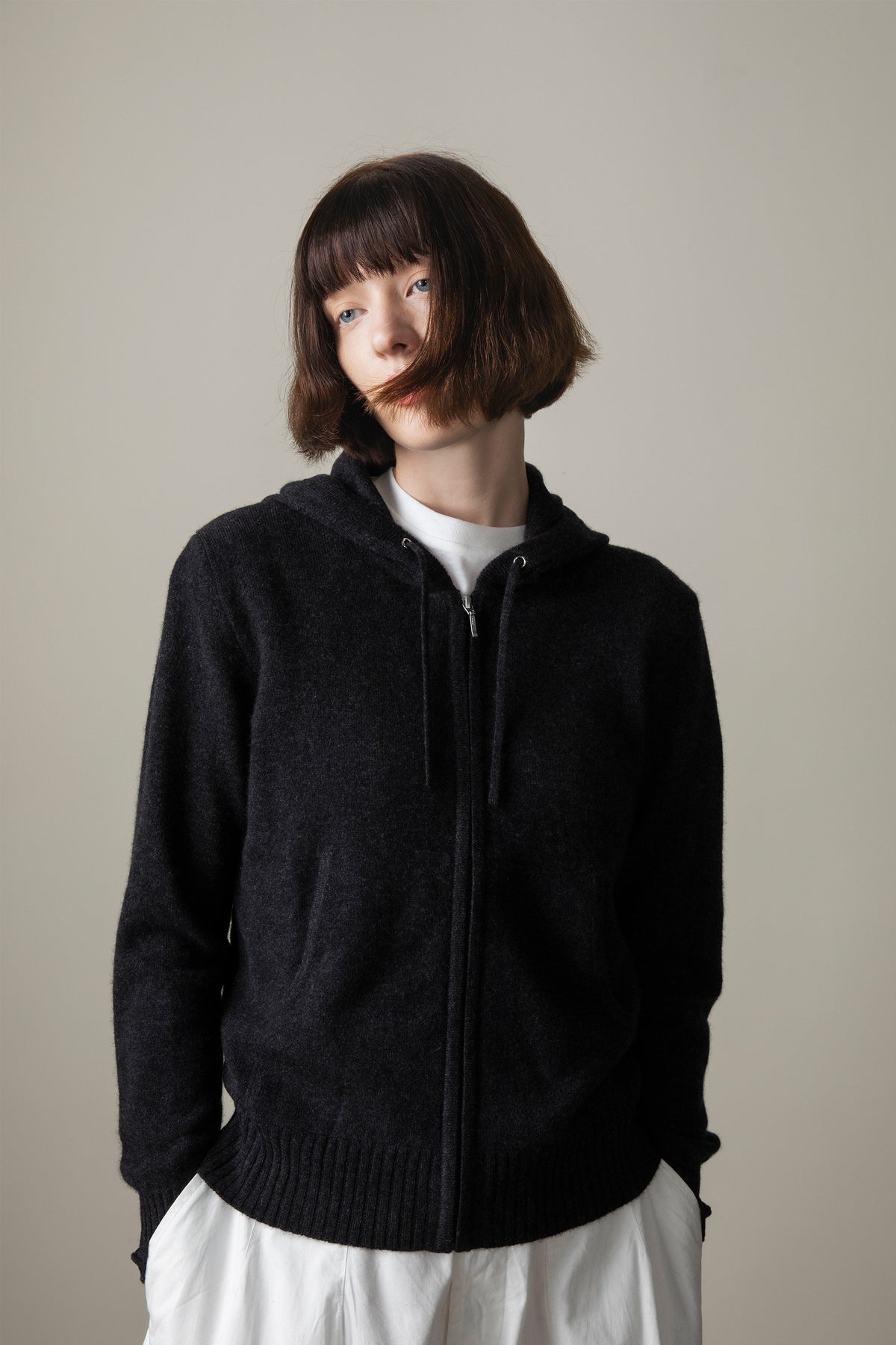 Unisex Cashmere Zip Hoodie in charcoal, full-zip front with drawstring hood and ribbed hem, styled over a white tee