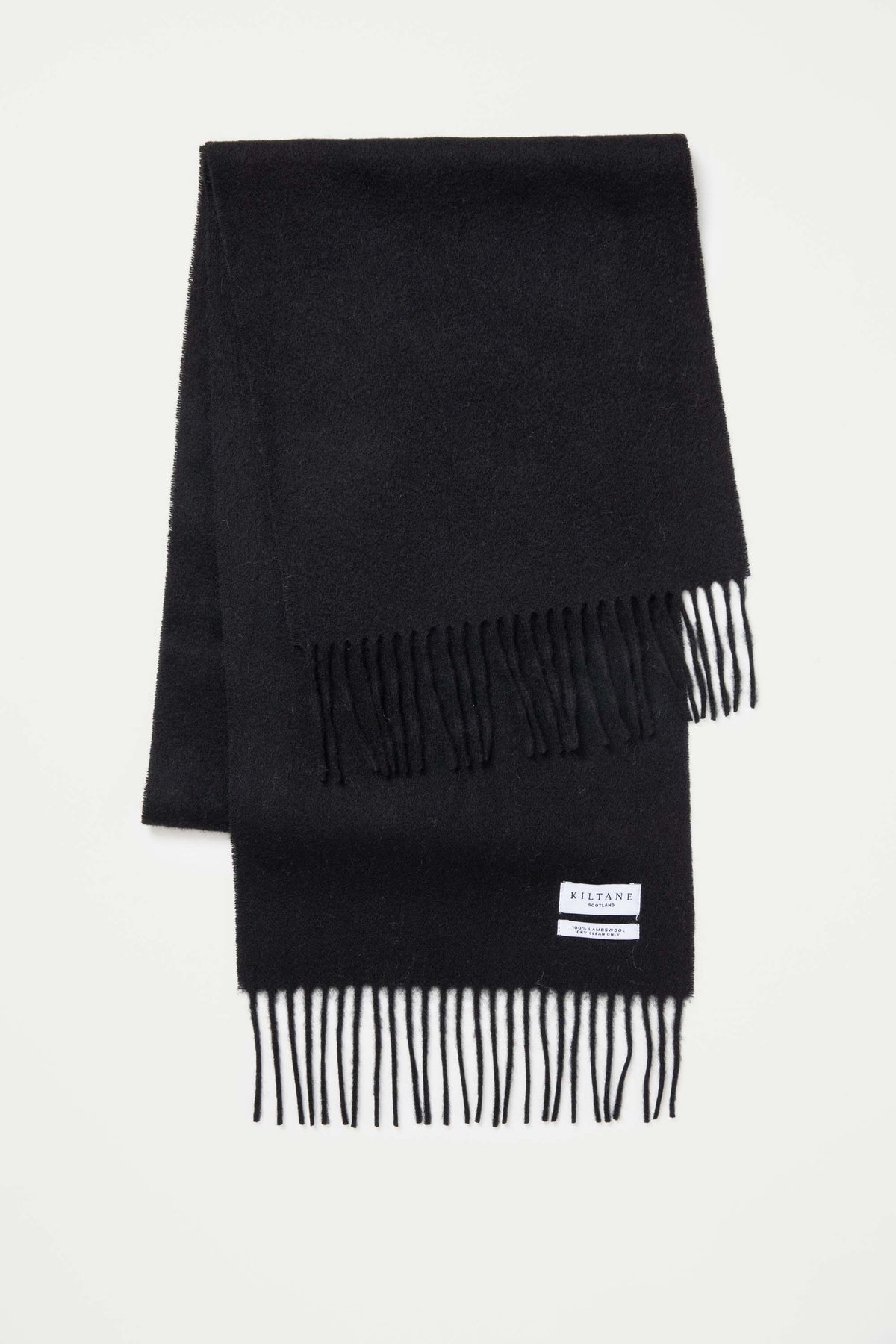 Kiltane Solid Lambswool Scarf in Black folded flat showing fringed ends and brand label