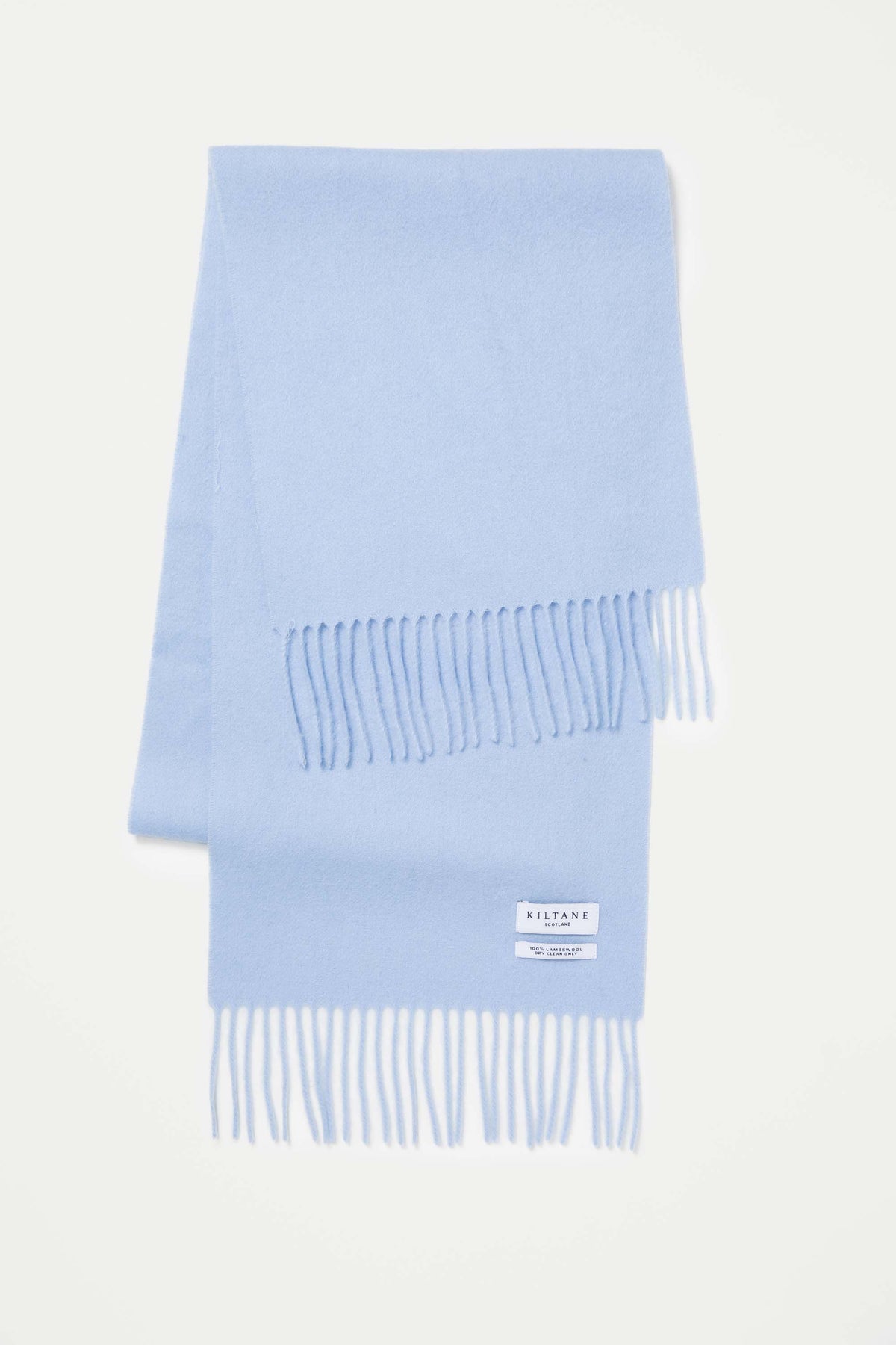 Kiltane Solid Lambswool Scarf in Cashmere Blue folded flat showing fringed ends and brand label detail