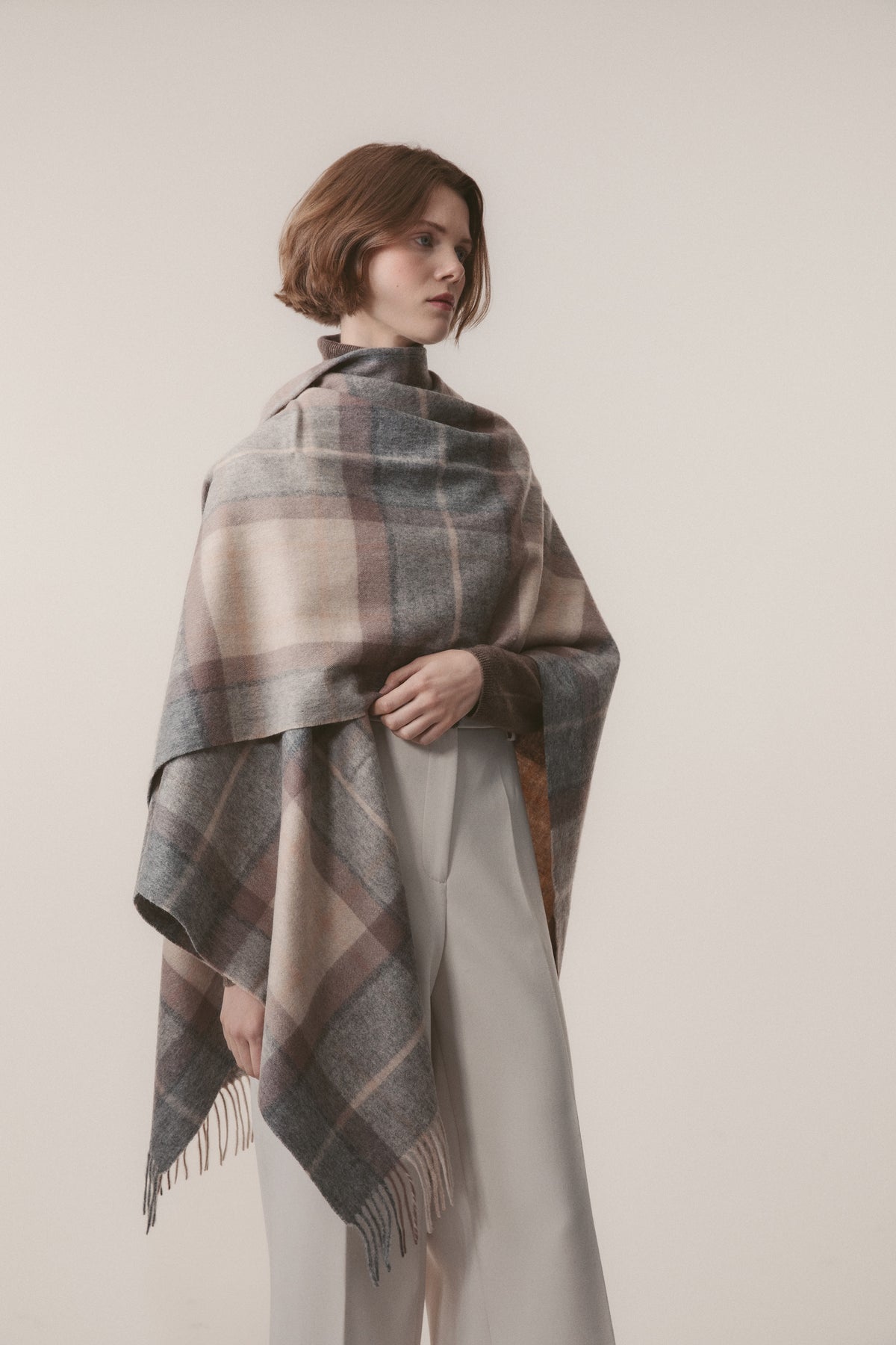Heritage Tartan Lambswool Wrap in Mackellar Natural draped over shoulders, showing full plaid pattern with fringed edge detail