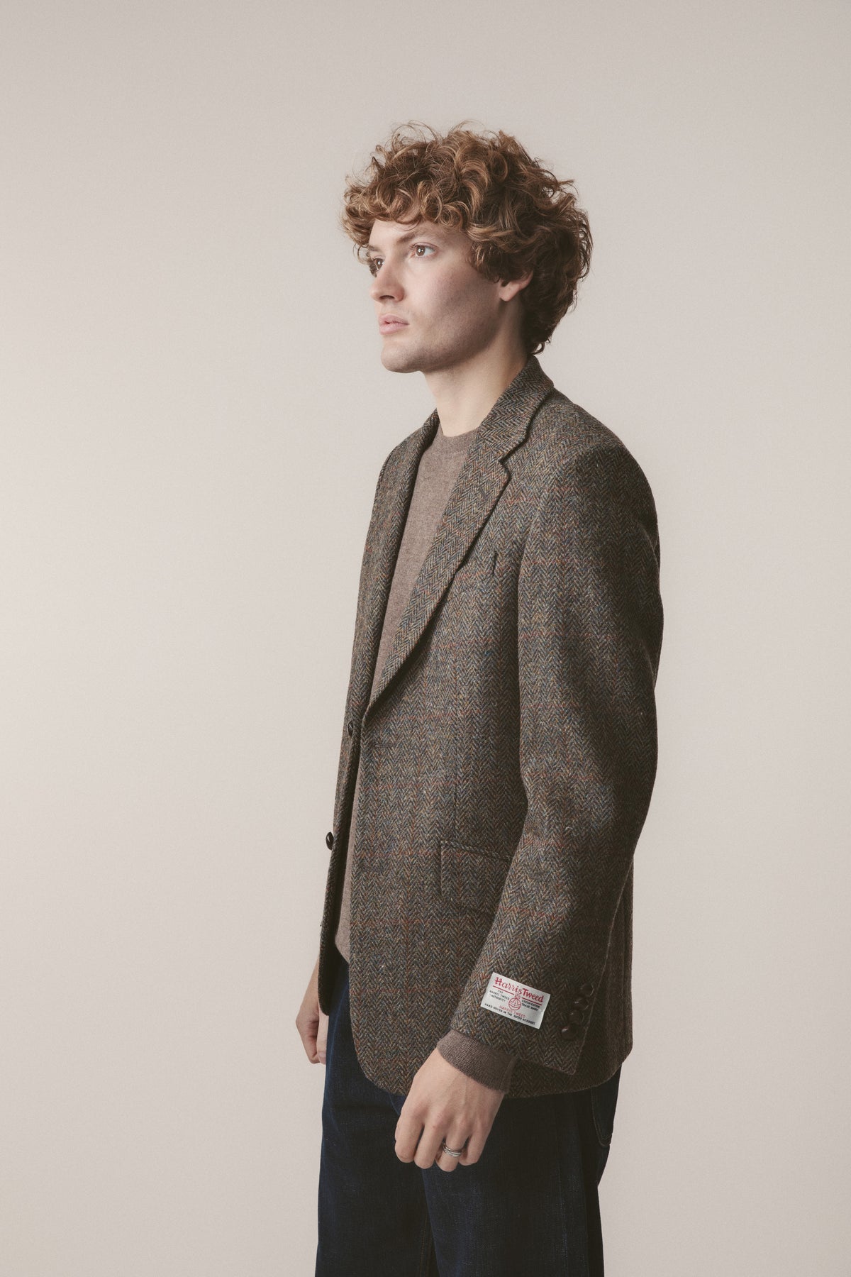 Men's Harris Tweed Finlay Jacket in brown check, side profile view showing herringbone weave and Harris Tweed label on sleeve