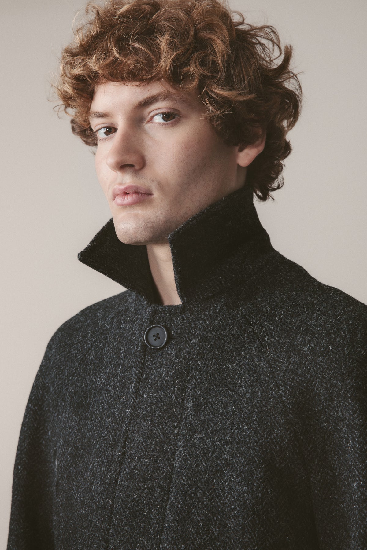 Close-up of Men's Harris Tweed Ottavio Pea Coat in deep charcoal showing raised stand collar and button closure detail