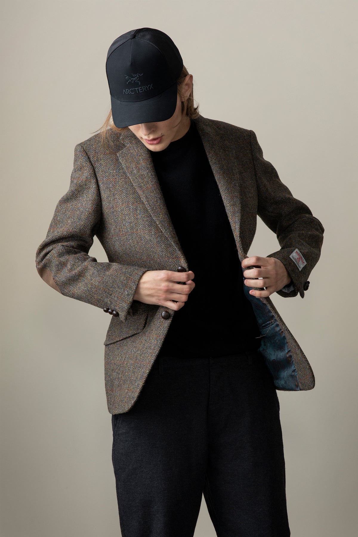 Model opening Men's Harris Tweed Patrick Jacket in brown check, showing blue satin lining and dark button details