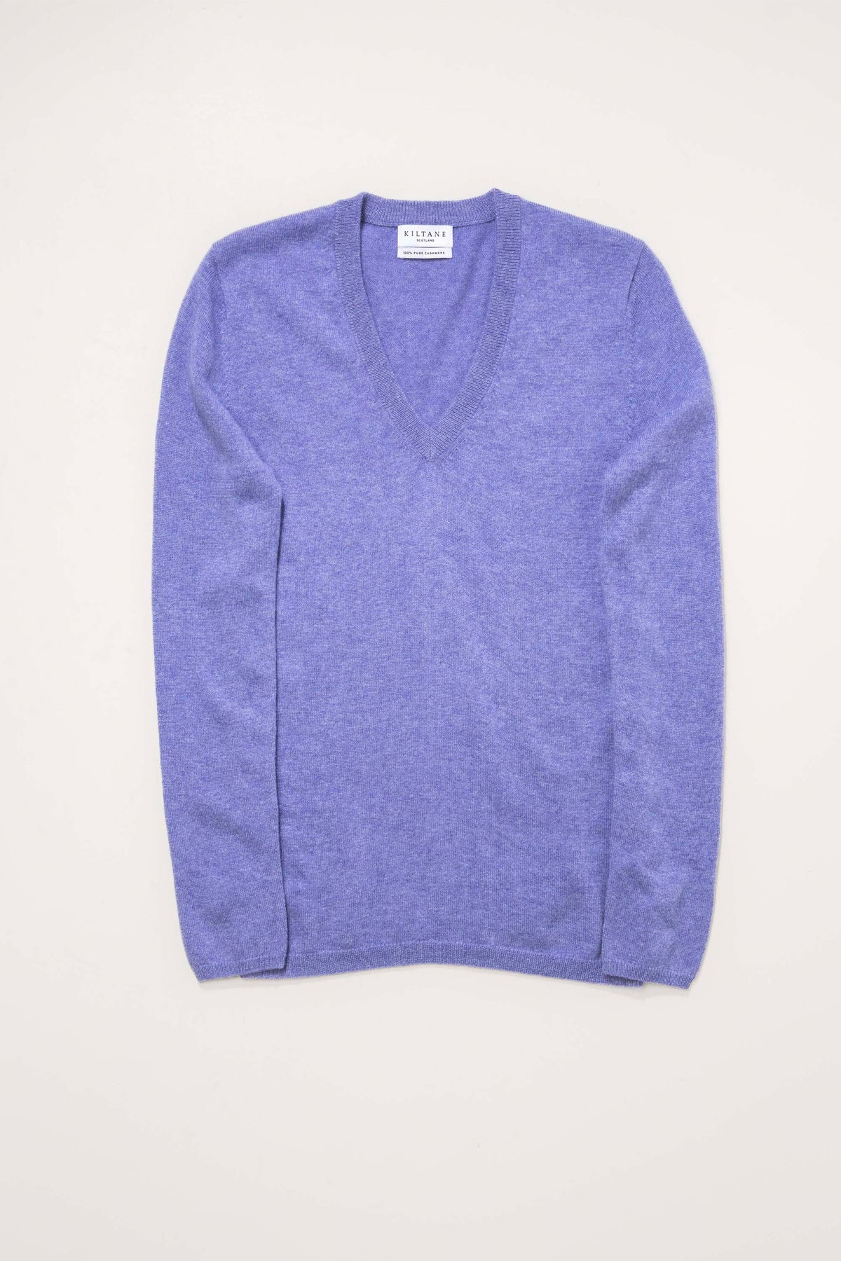 Kiltane Women's Cashmere V Neck Jumper in Wisteria laid flat, showing the deep V-neckline and relaxed long-sleeve fit