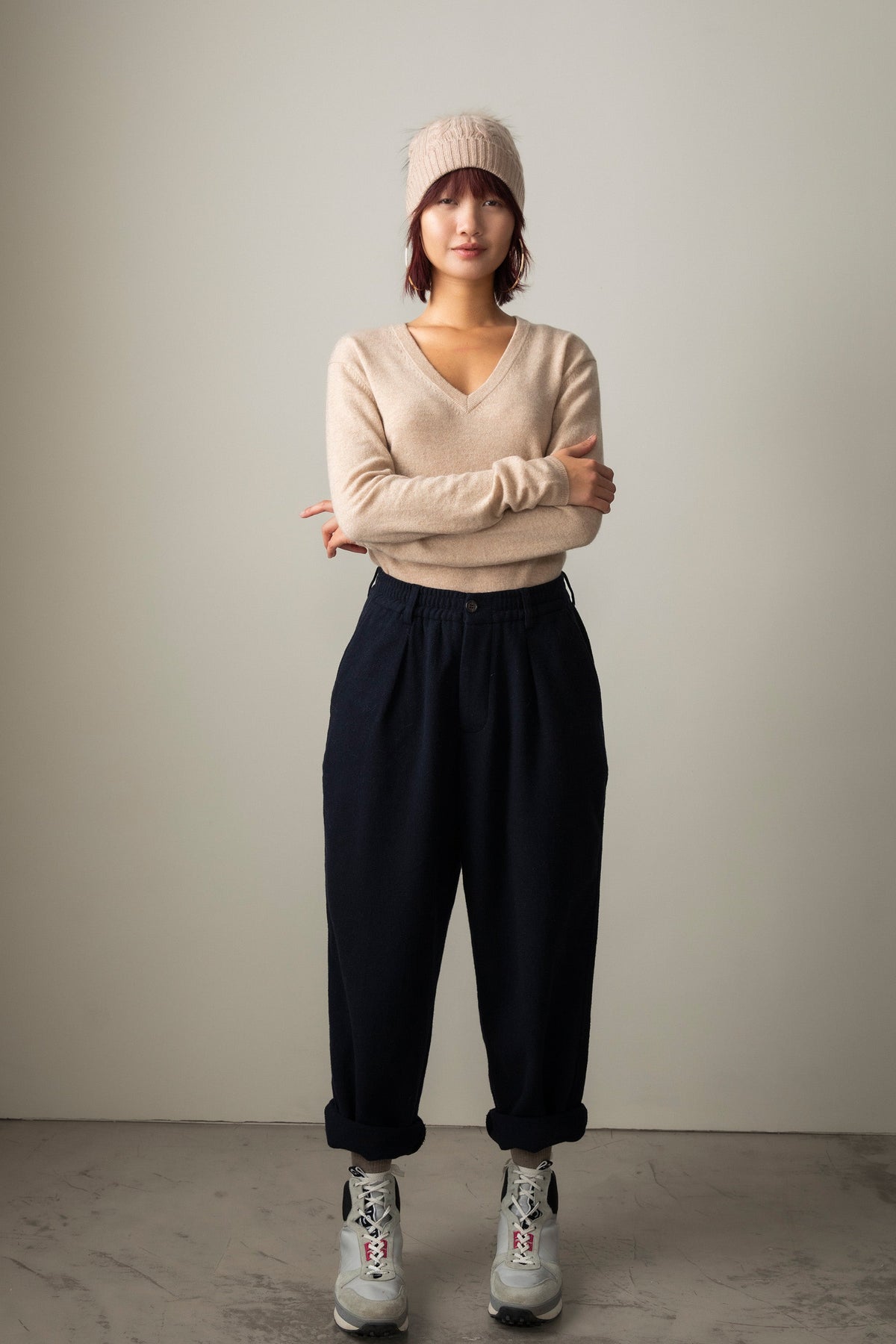 Women's Cashmere V Neck Jumper in Vicuna, a soft beige lightweight knit with ribbed neckline, cuffs, and hem, styled full-length